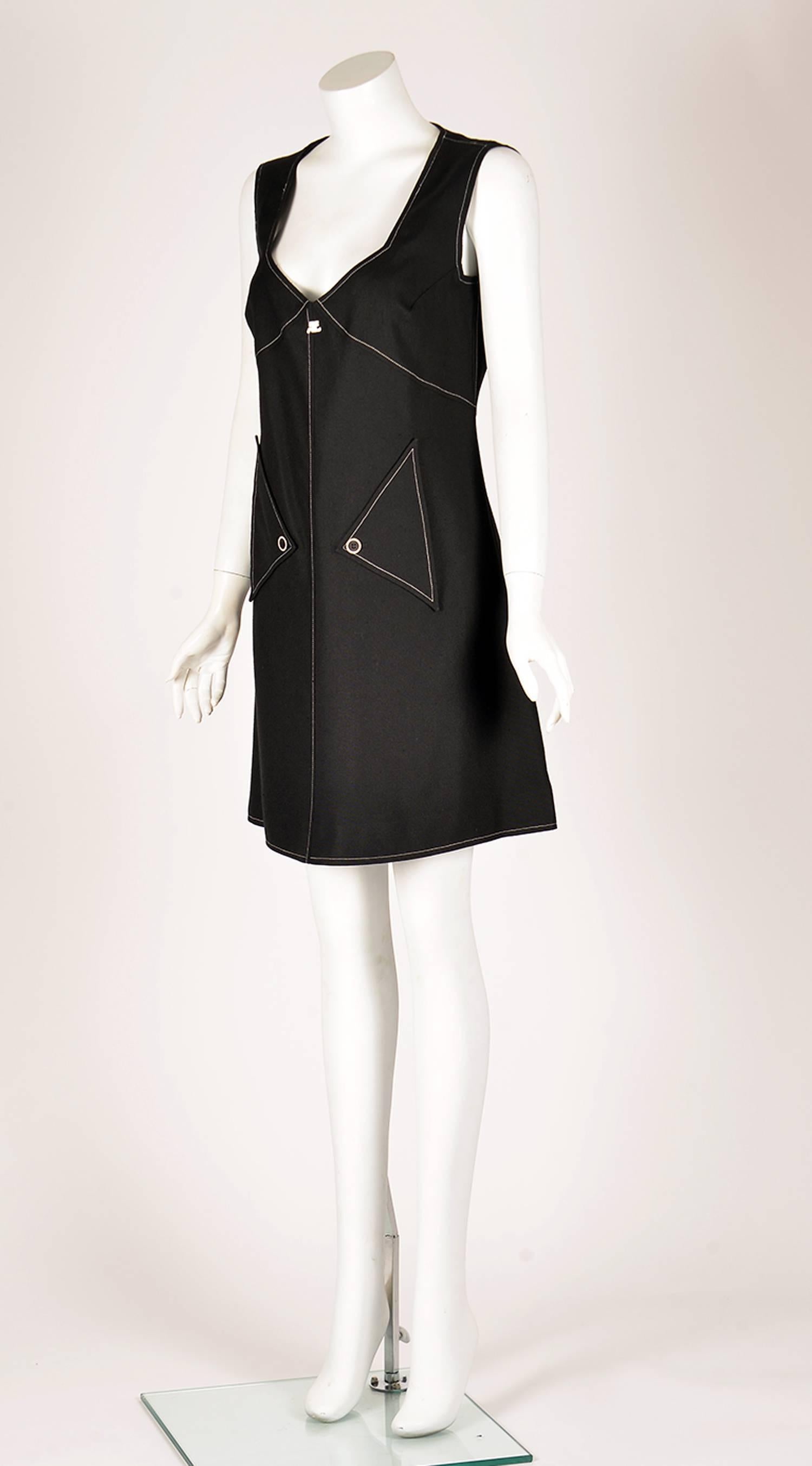 1980s does the 60s with this wonderful Courreges day to evening dress. A loose A-line black rayon dress has a sweetheart neckline and contrasting white stitching. The dress has two triangle pockets in the front, with a single button closure, as well