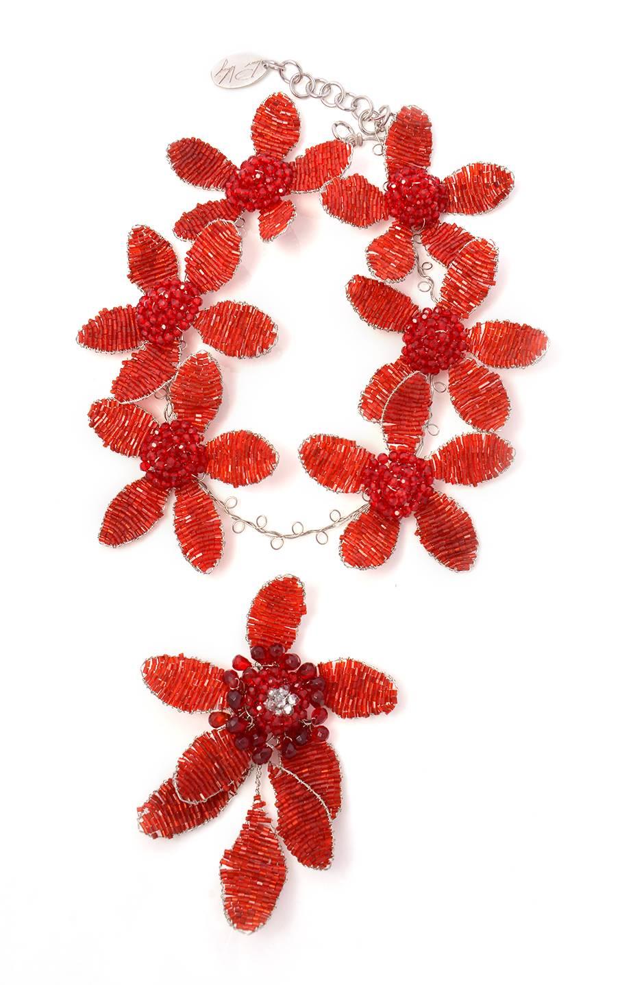 
From the Estate of Joan Rivers. Hand crafted by Joe Vilaiwan, this red bugle beaded floral necklace has six five-petaled flowers, each with a domed multifaceted bead center, plus a brooch that can be removed from the necklace as a seventh flower.