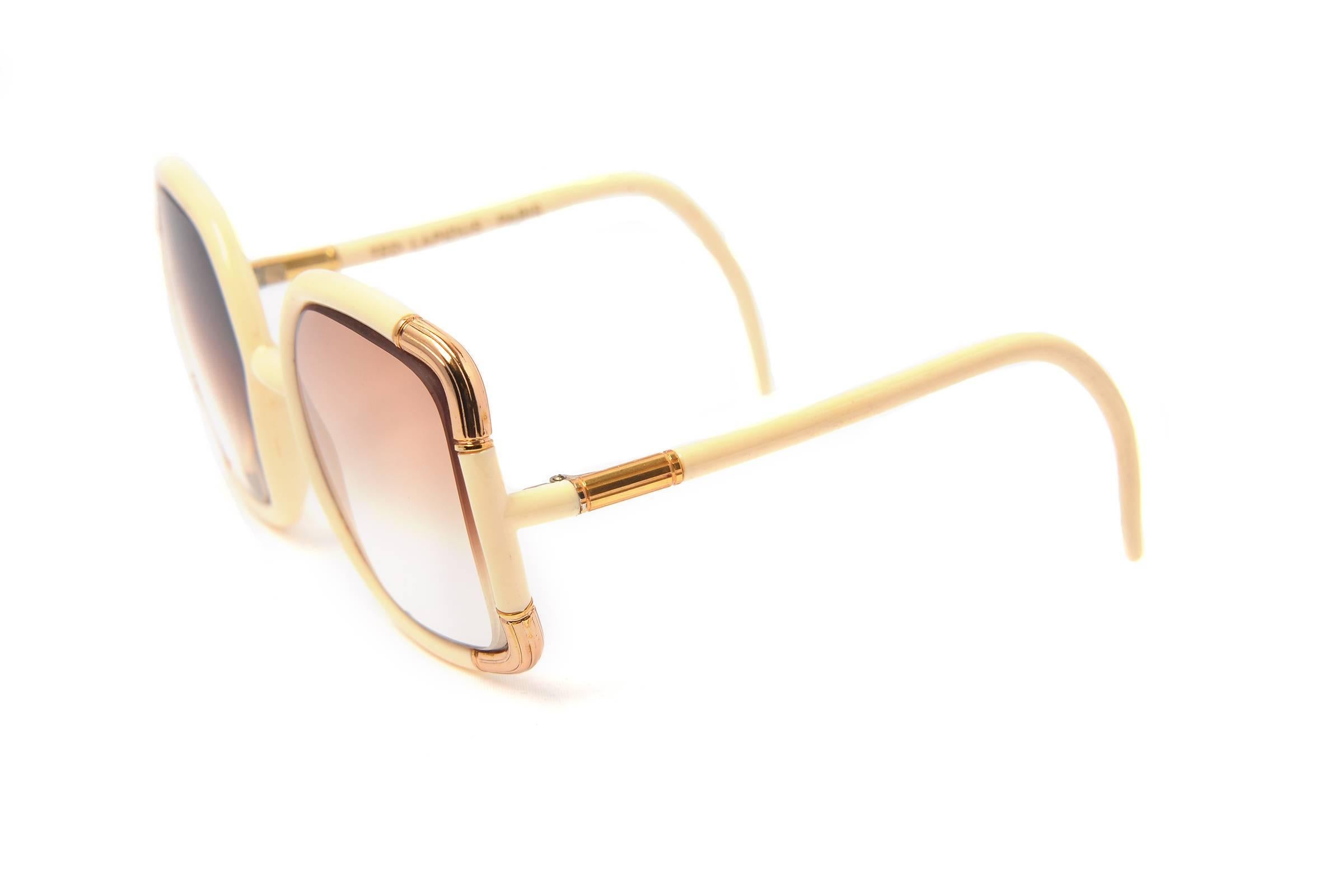 
1970s Ted Lapidus Paris sunglasses. These fun and flirty oversized sunglasses are square-shaped and feature white single bridge frames with gold-tone accents. The lenses have a grey and pink gradient that fades out at the bottom of the lens.