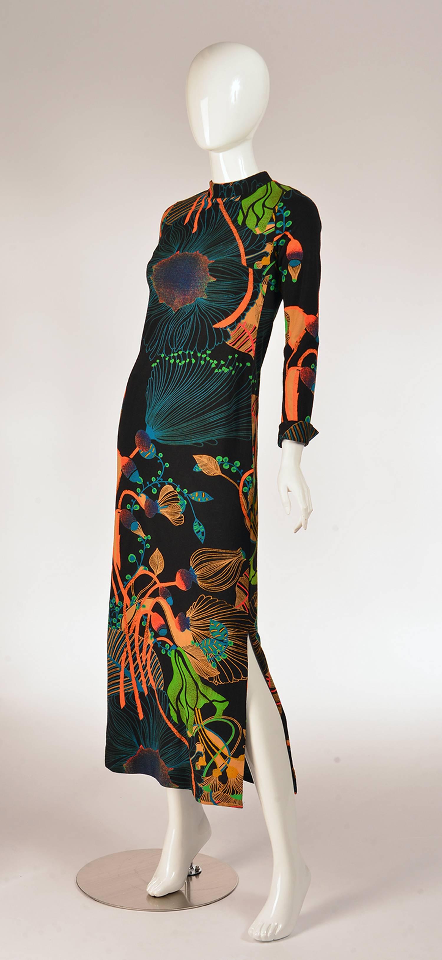 Fascinating 70's Lavin dress. This knit wool dress features a gorgeous, bold neon floral print on black. Vibrant blues, neon orange, leaf greens, blushing pink, walnut, and speckles of purples and reds appear throughout the line-work poppy and lotus