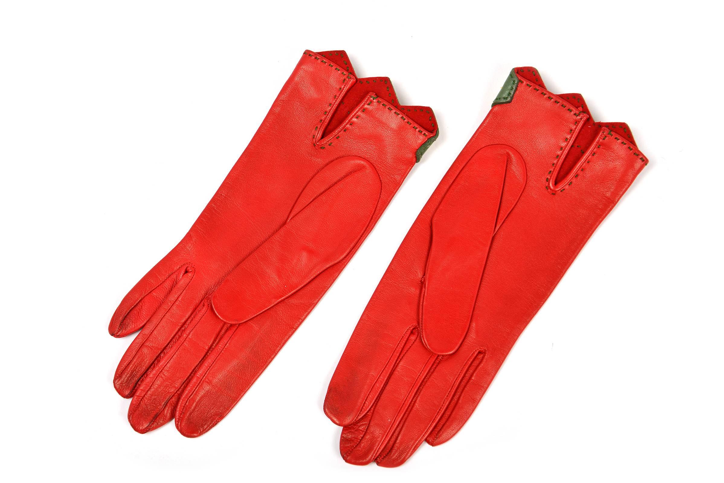 
Brilliant red leather gloves with green leather trim and gold metal studs.  A pop of green top-stitching along the green leather strip continues to the back slit. Suede inside. A great accent to you winter wardrobe!
 
Modern US size 6 -