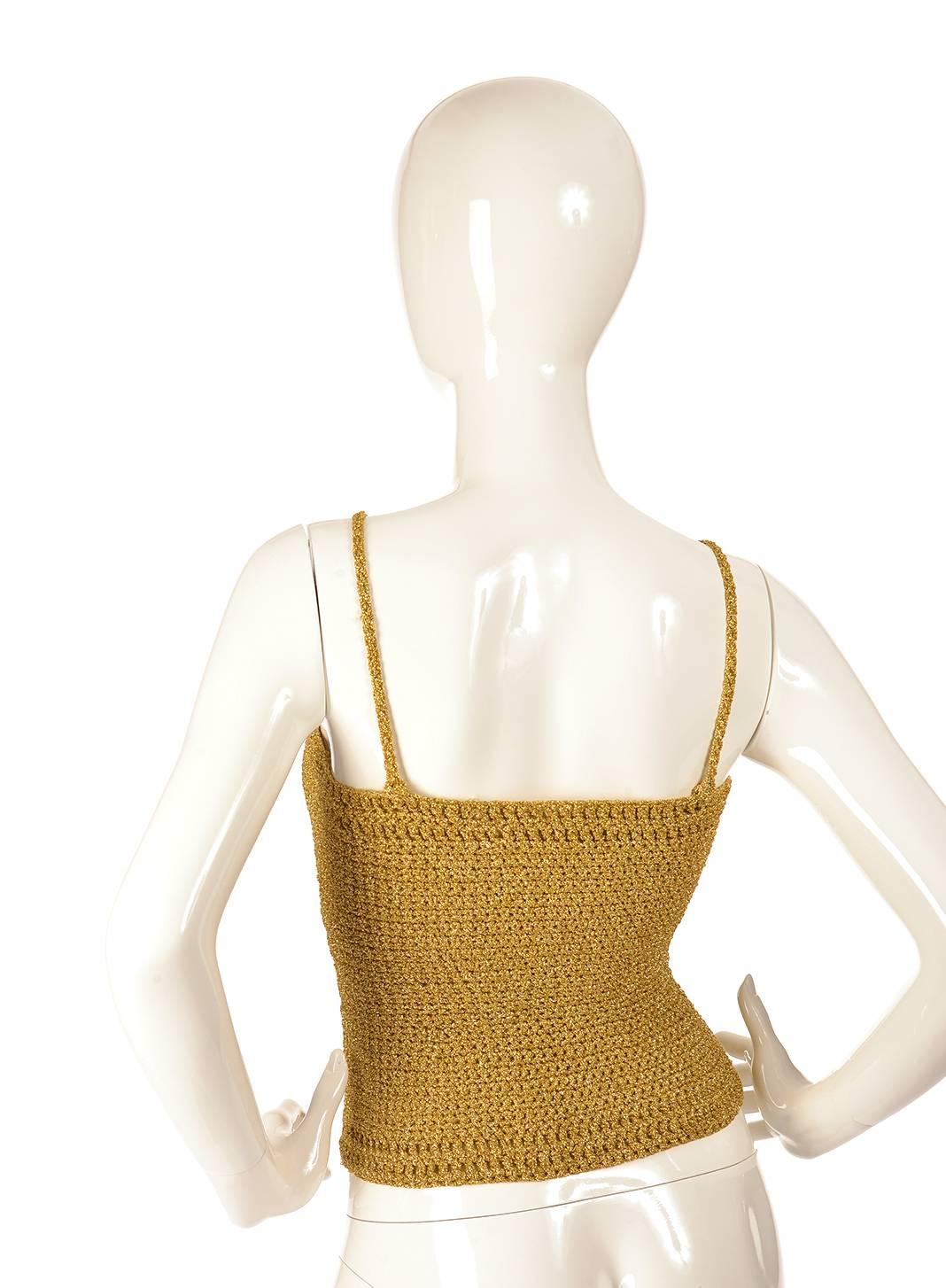 
Fun and girly gold knit metallic crop top. This top is tightly knitted together in a weave pattern, using gold yarn with metallic gold thread interspersed through out the top. The top has spaghetti straps, and can be pulled over the head.