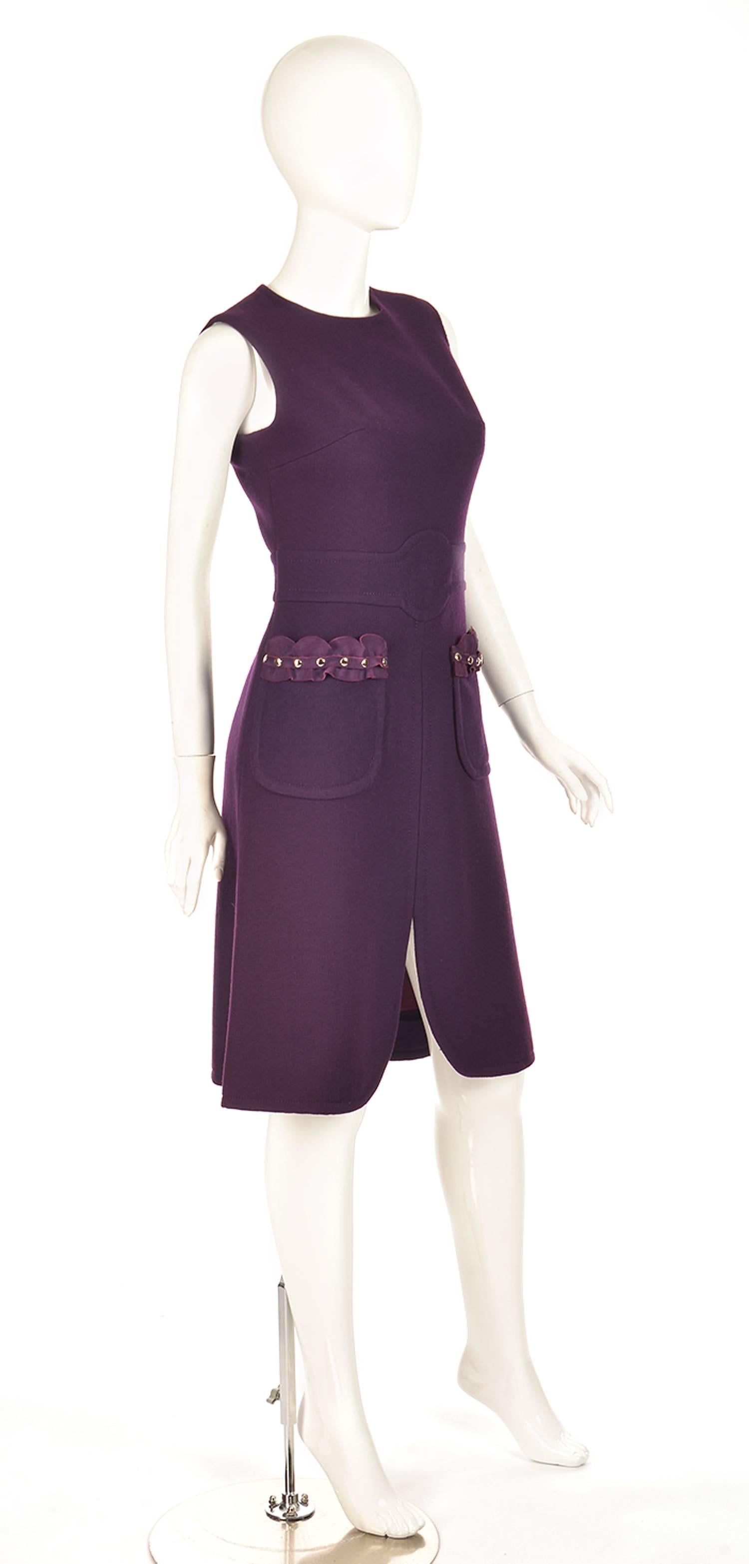 
Rare.... this wool sleeveless, crewneck sheath dress by Pierre Cardin is absolutely charming! The dress features a belt-like center waist panel and a tulip-like slit in the center of the front of the dress. The dress' two curved front pockets are