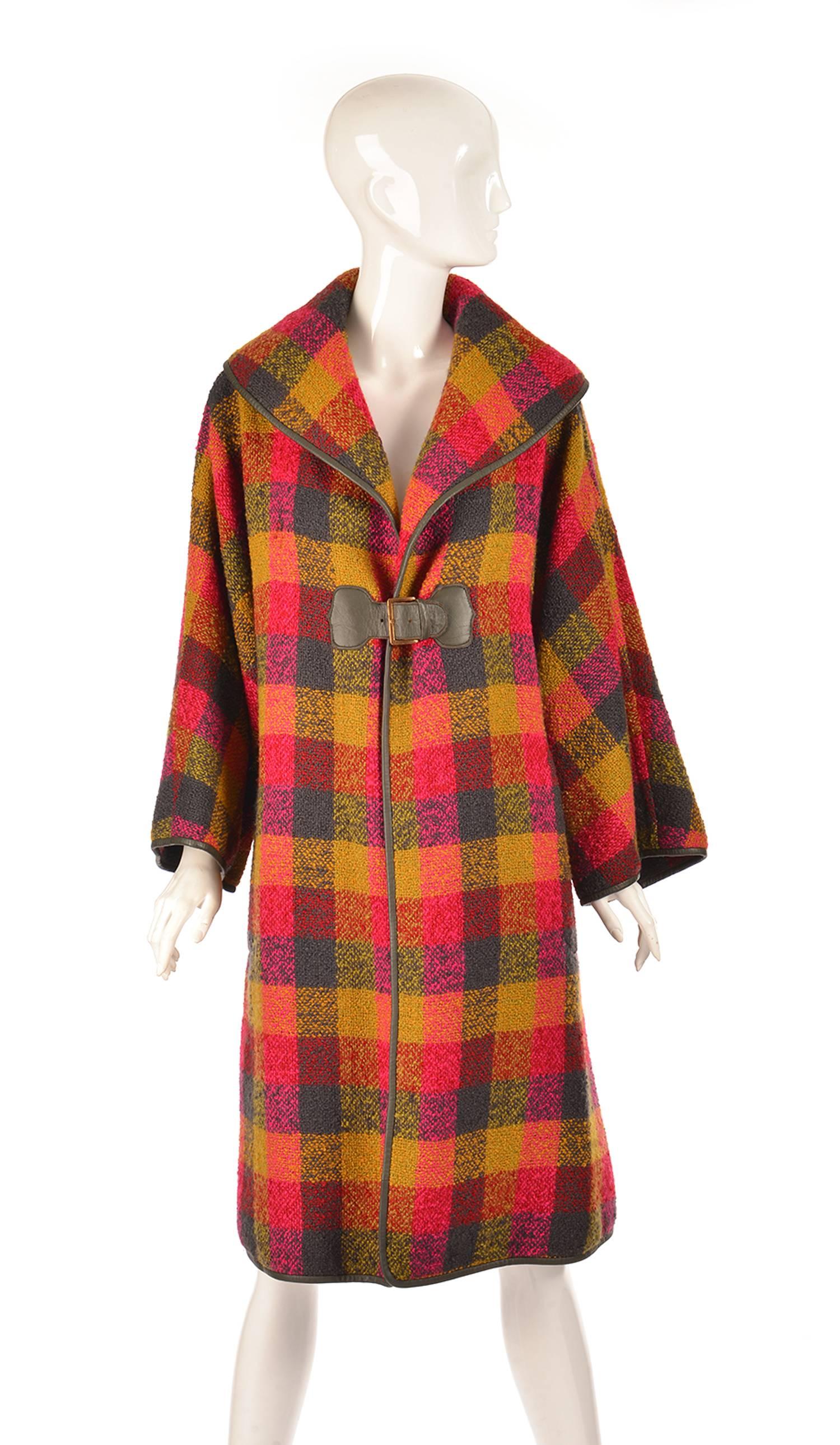 Gorgeous knee-length Bonnie Cashin coat in bright and festive fall colours. This gingham coat features pewter leather trim and a single buckle closure below the lapel. A striking and comfy addition to your closet!

Makes for a great gift for any