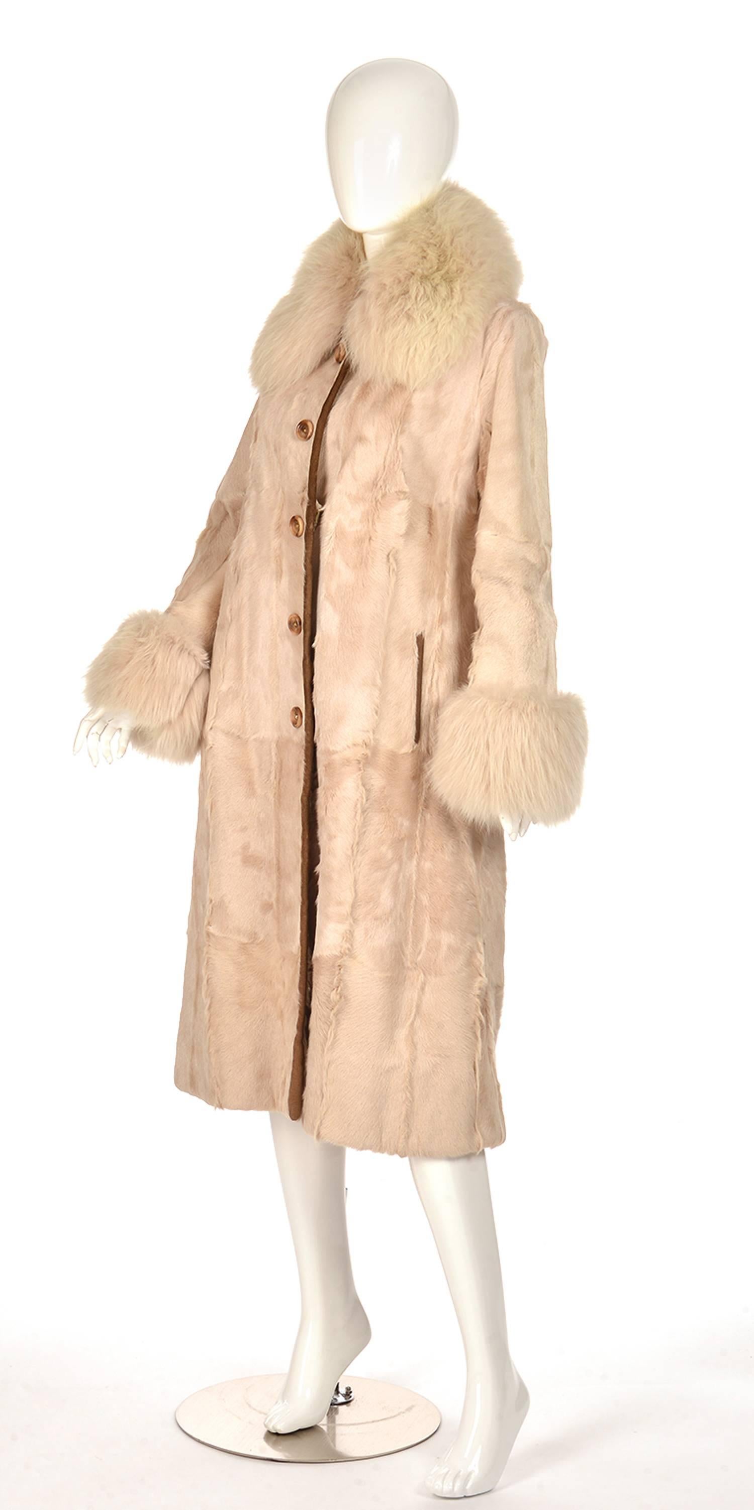 
Gorgeous midi length angora rabbit and calf fur coat. The coat primarily consists of bisque-colored calf fur, and is accented with vanilla-colored rabbit fur at the collar and wrists. The coat features caramel-colored leather piping accenting the