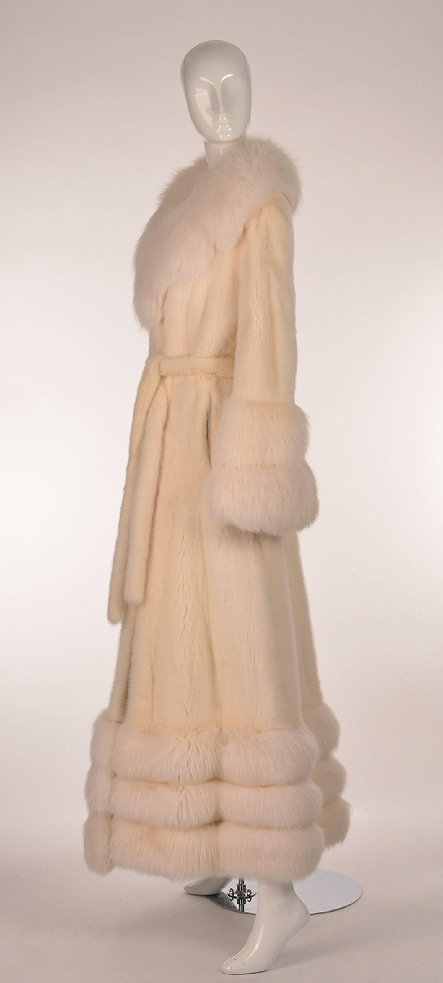 
This spectacular coat is floor length and contains both mink and rabbit fur. The coat is primarily white mink, and is accented with white angora rabbit fur in the collar, sleeves, and zip off hem. The coat is fully lined, and features a gorgeous