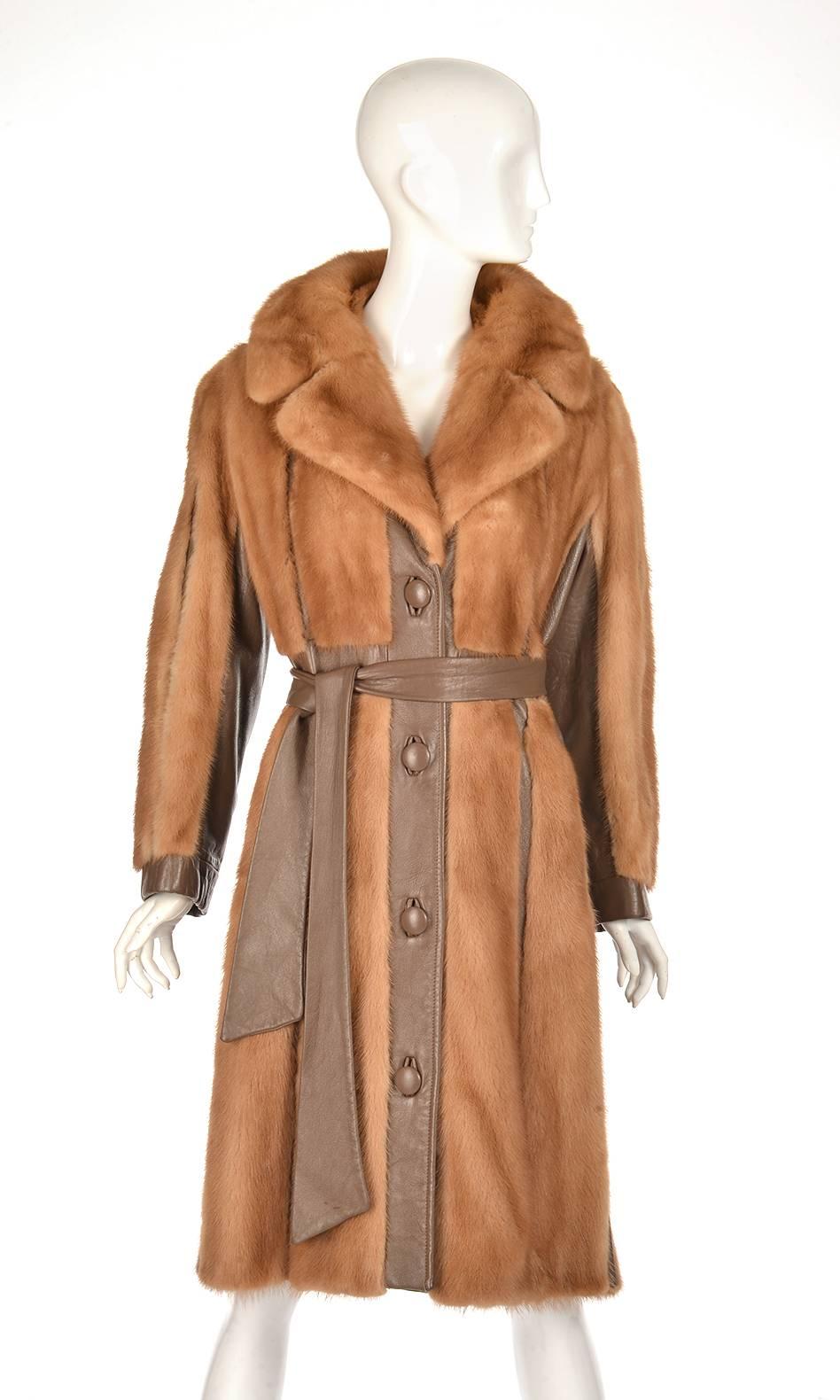 
This Aladino Stefani Originals coat is as edgy as it is polished. The coat is composed of caramel mink panels interposed with chocolate brown leather, a mink collar, and a leather belt. The coat features four large leather buttons, and is lined.