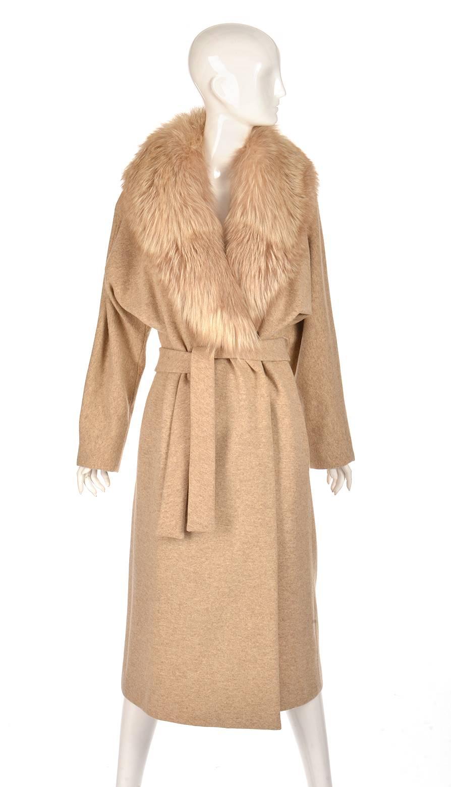 This romantic gold, cream, and fox coat was designed by Bill Blass. The coat is composed of wool accented with a fox fur collar. The coat has a loose, airy silhouette with an adjustable belt. This coat is an elegant classic.

It is in lovely