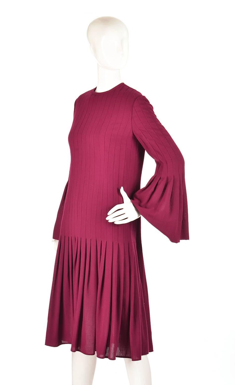 
Romantic 1960s Pierre Cardin dress. This knee-length dress appears to be composed entirely of open and closed pleats. The pleated look of the dress creates a vertical stripe effect that opens up at the trumpet sleeves and trumpet skirt. The dress