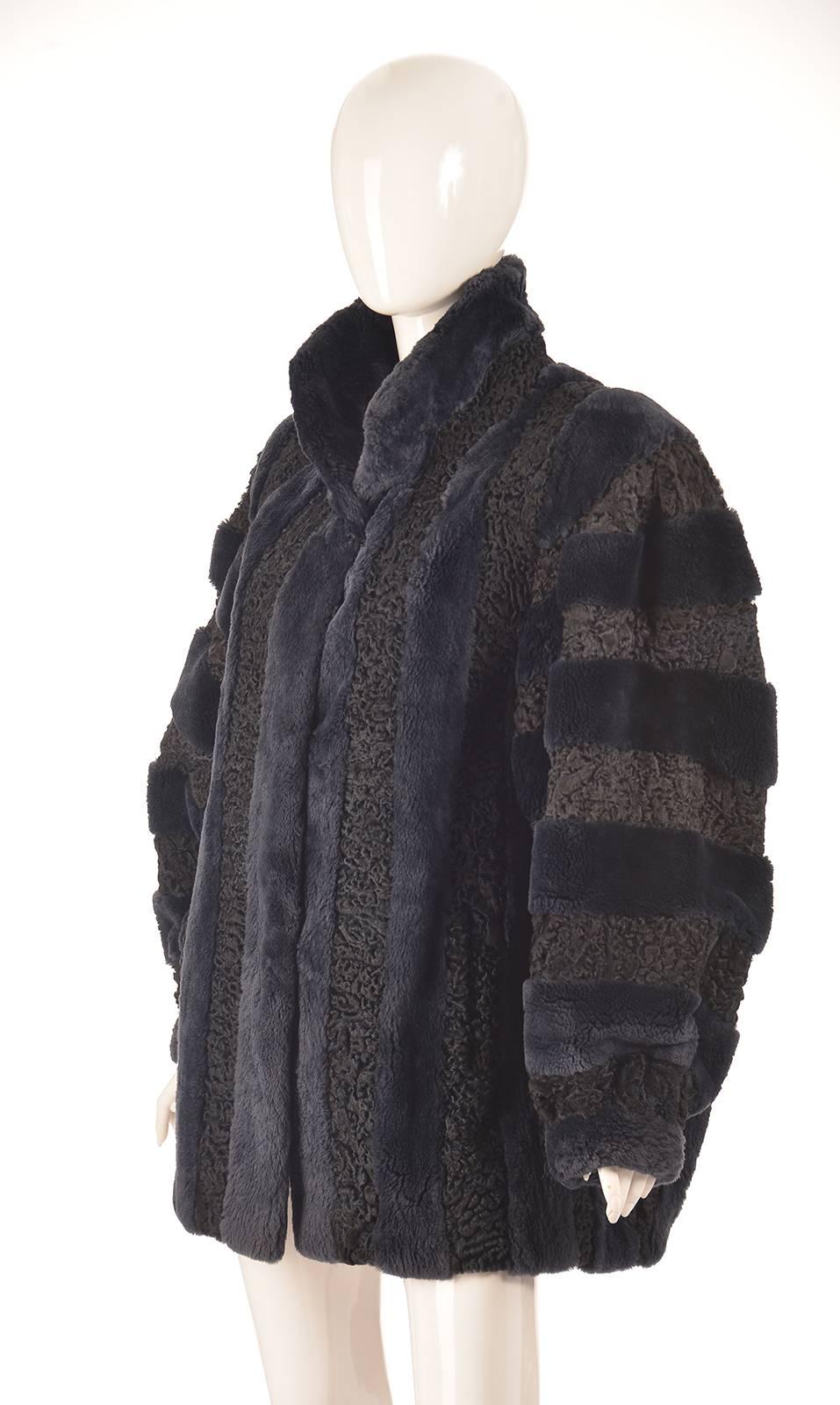 
Fantastically decadent midnight 1980s Christian Dior Fourrure Persian lamb and shaved mink coat. This sumptuous coat is composed of Persian lamb and shaved mink, alternating horizontally on the arms, and vertically on the torso. This sumptuous,