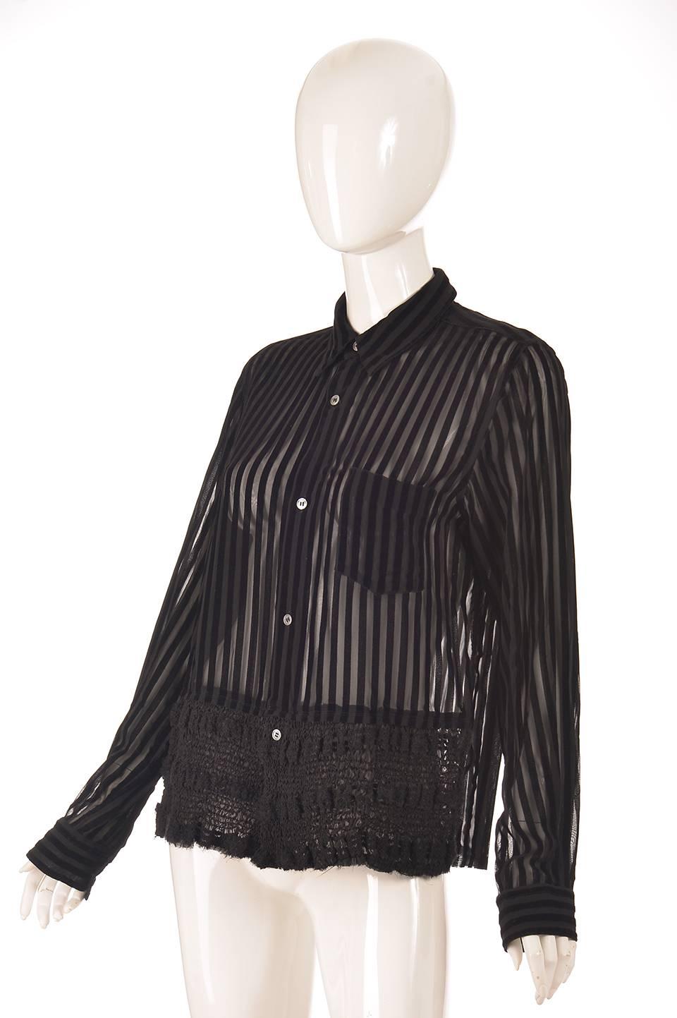 
This edgy sheer and velvet striped shirt was designed by Junya Watanabe of Comme des Garcons fame. The blouse has a front left breast pocket, a delicately sheared front hem, and is accented by five mother of pearl buttons going down the front of