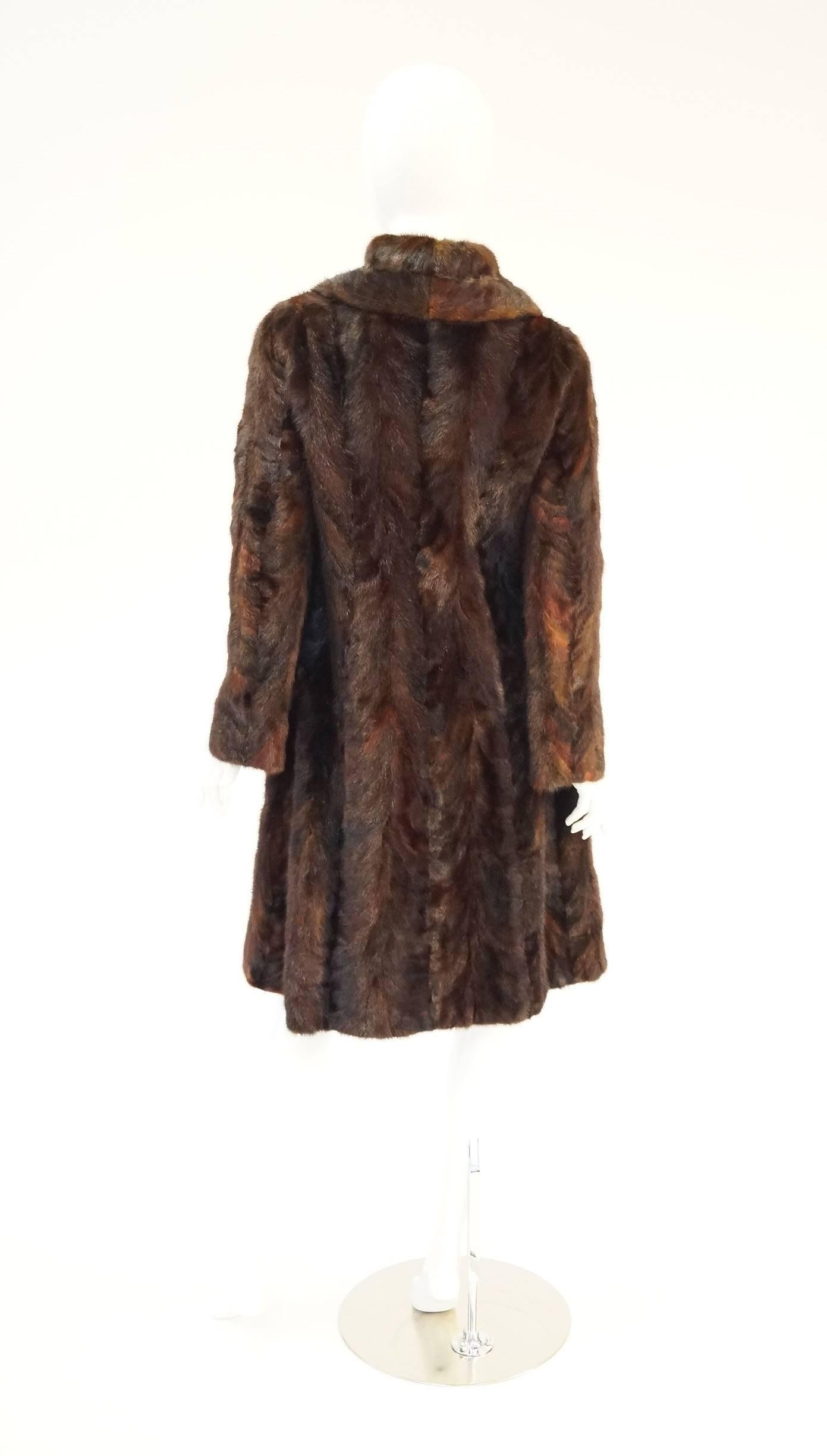
This Vintage Oscar de la Renta sable coat for Montaldo's is absolutely elegant. The coat features an exaggerated peter pan collar and front placket. Long sleeves. Large pocket flaps. Knee length. The fur is a gorgeous mix of mottled browns, reds,