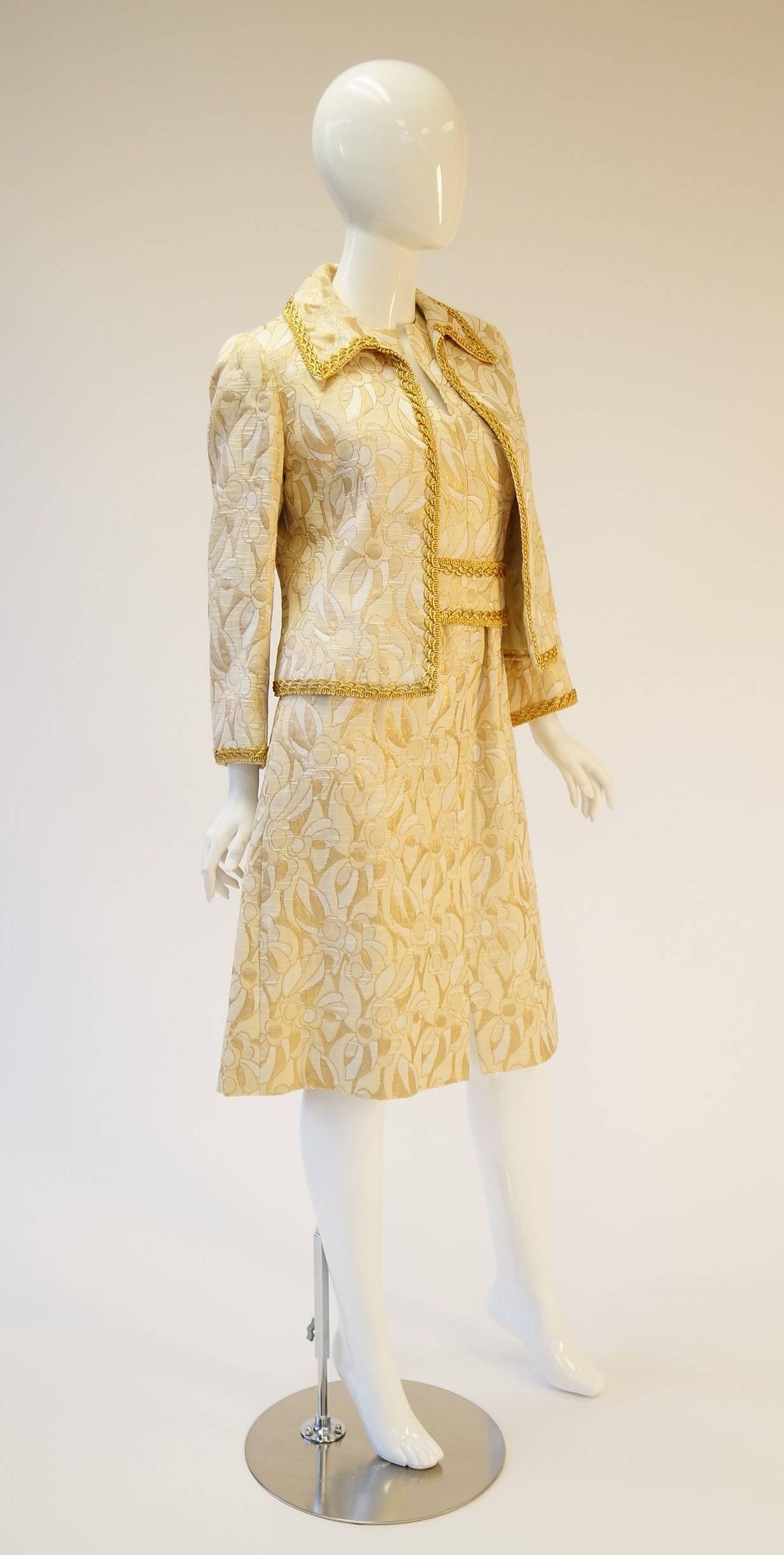 Vintage Mollie Parnis Gold and Cream Dress Suit

Gorgeous dress suit by Mollie Parnis boutique for Lord and Taylor. The dress suit features a plush gold and cream abstract brocade pattern on both the dress and the jacket. The jacket has long sleeves