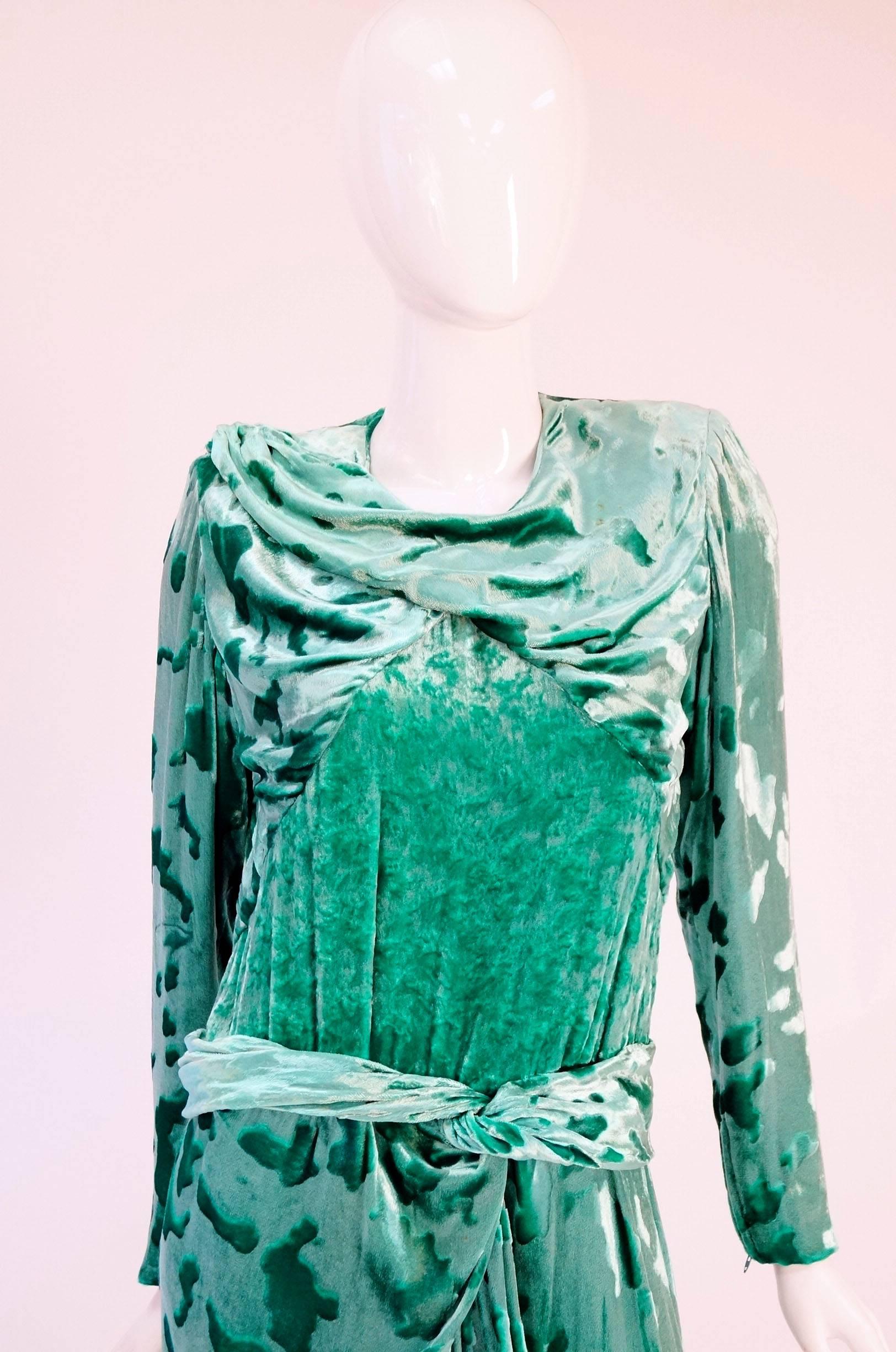 
Striking green crushed velvet by couturier James Galanos for Neiman Marcus! This fun, bright dress has long sleeves with zipper closures, a draped neckline, and padded shoulders. The dress is composed of an abstract crushed velvet fabric in