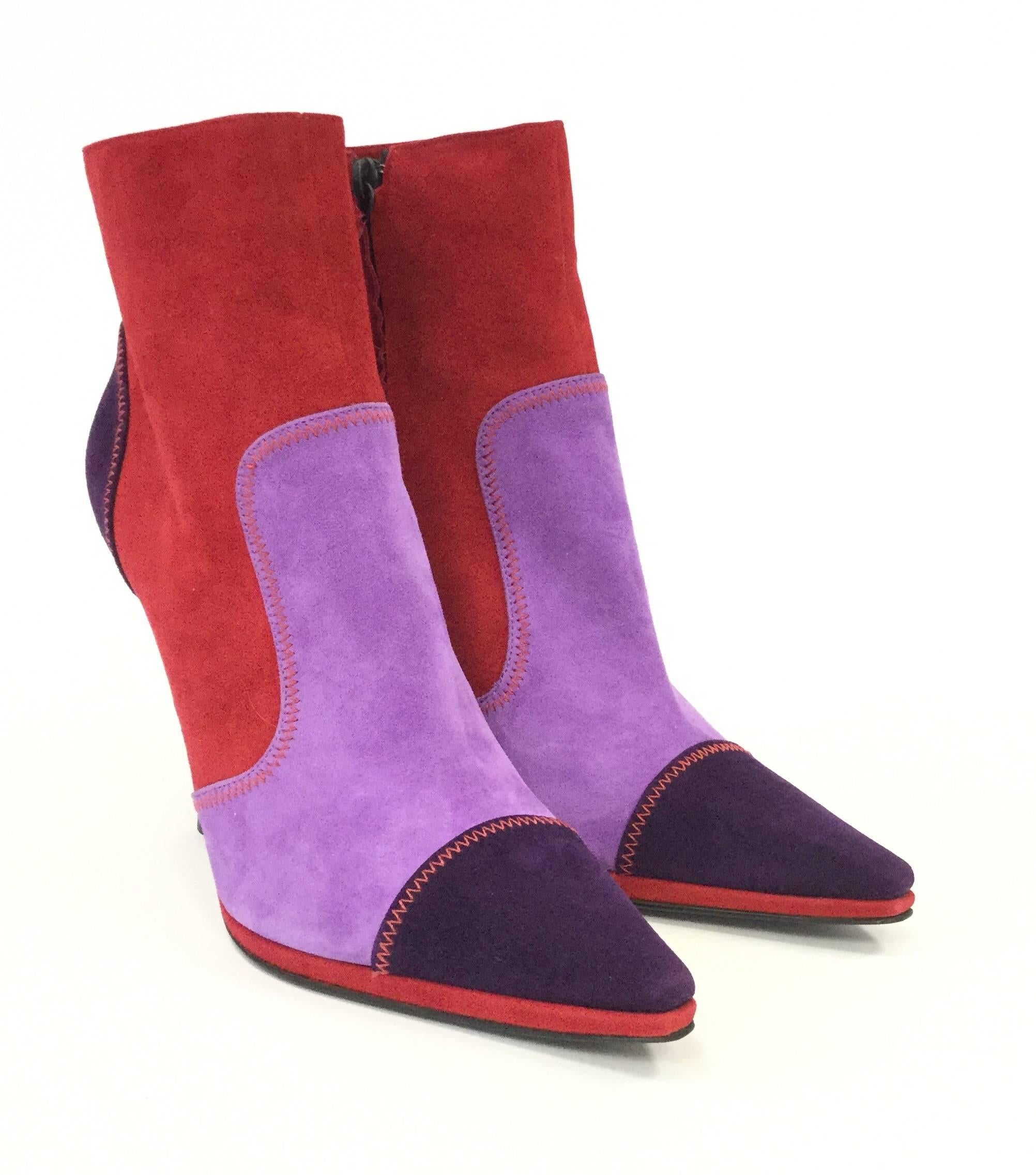 
New in box (NIB). Playful and sophisticated booties by Casadei. These suede booties are composed of multiple colorful panels of suede held together with red accent zigzag stitching. The shoes have deep purple toe and heel caps, violet vamps, and