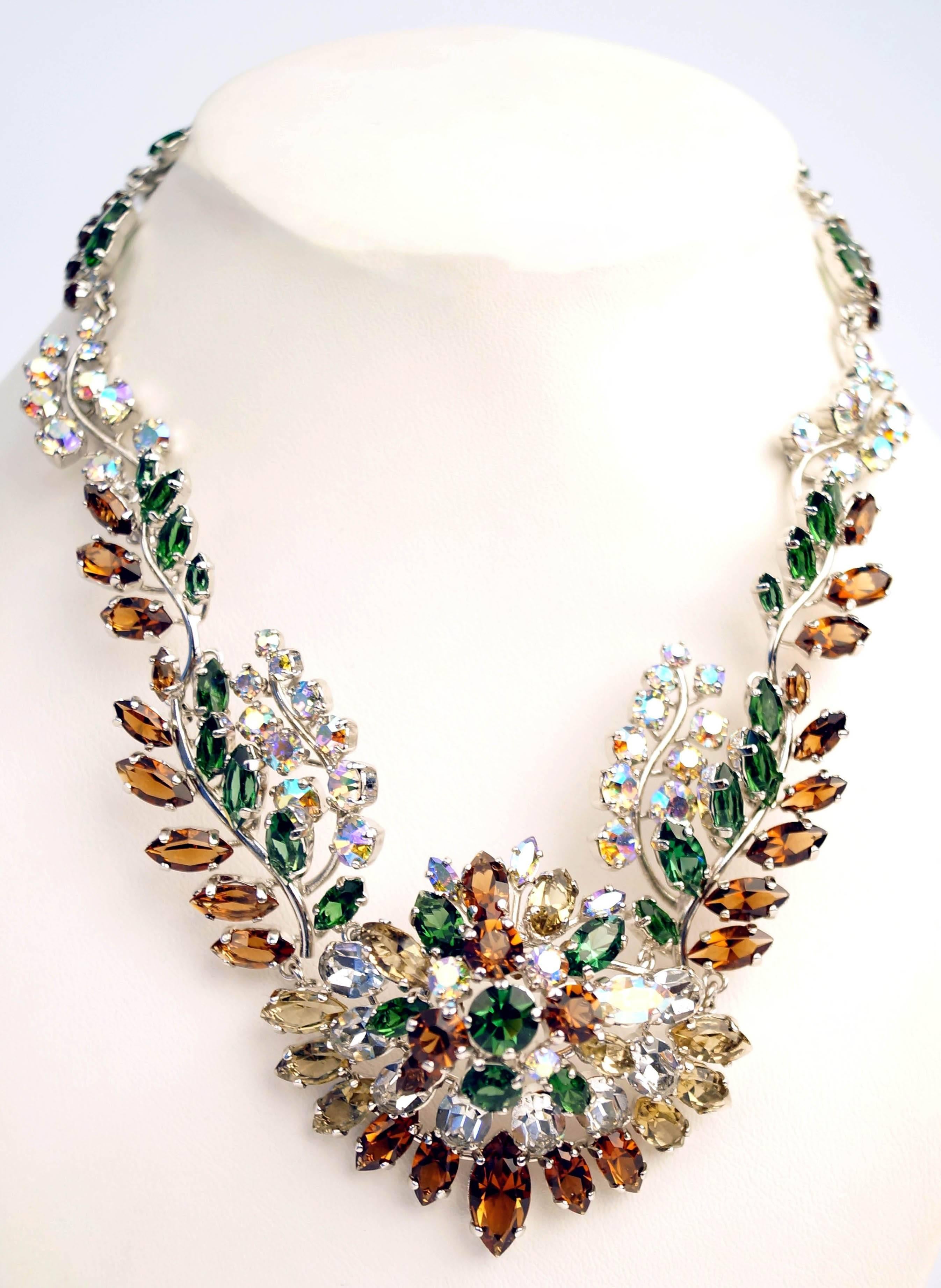 
This gorgeous necklace by Dior is composed of chocolate brown, green, and clear iridescent rhinestones in marquise and round multifaceted cuts. The necklace is on a silver-tone base with floral rhinestone arrangement. The necklace's purposefully
