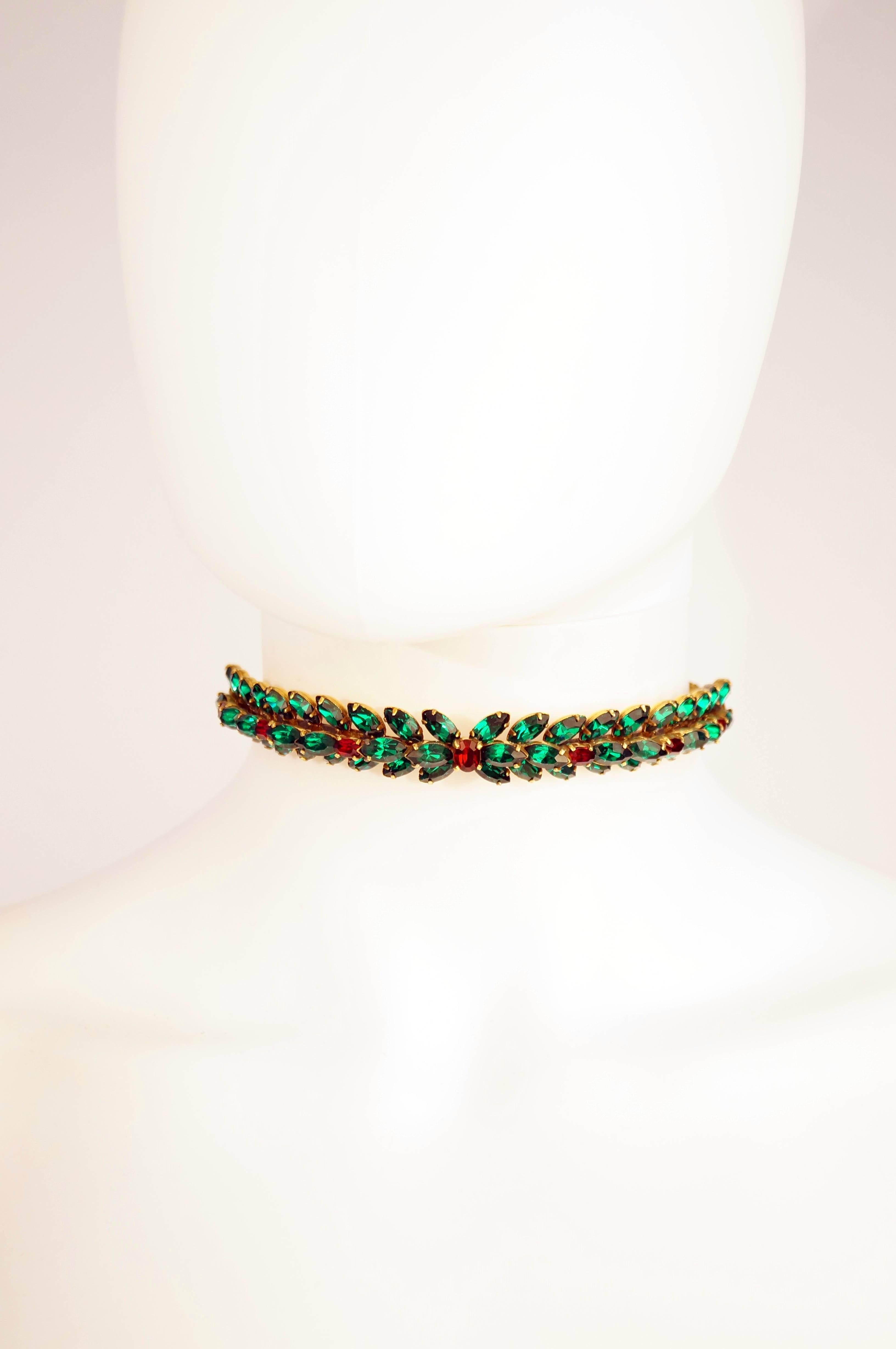 
Absolutely gorgeous stiff front choker necklace composed of a center strip of green marquise cut rhinestones over two strips of marquise cut rhinestones facing inwards in a  chevron-like fashion. The center strip of green rhinestones is