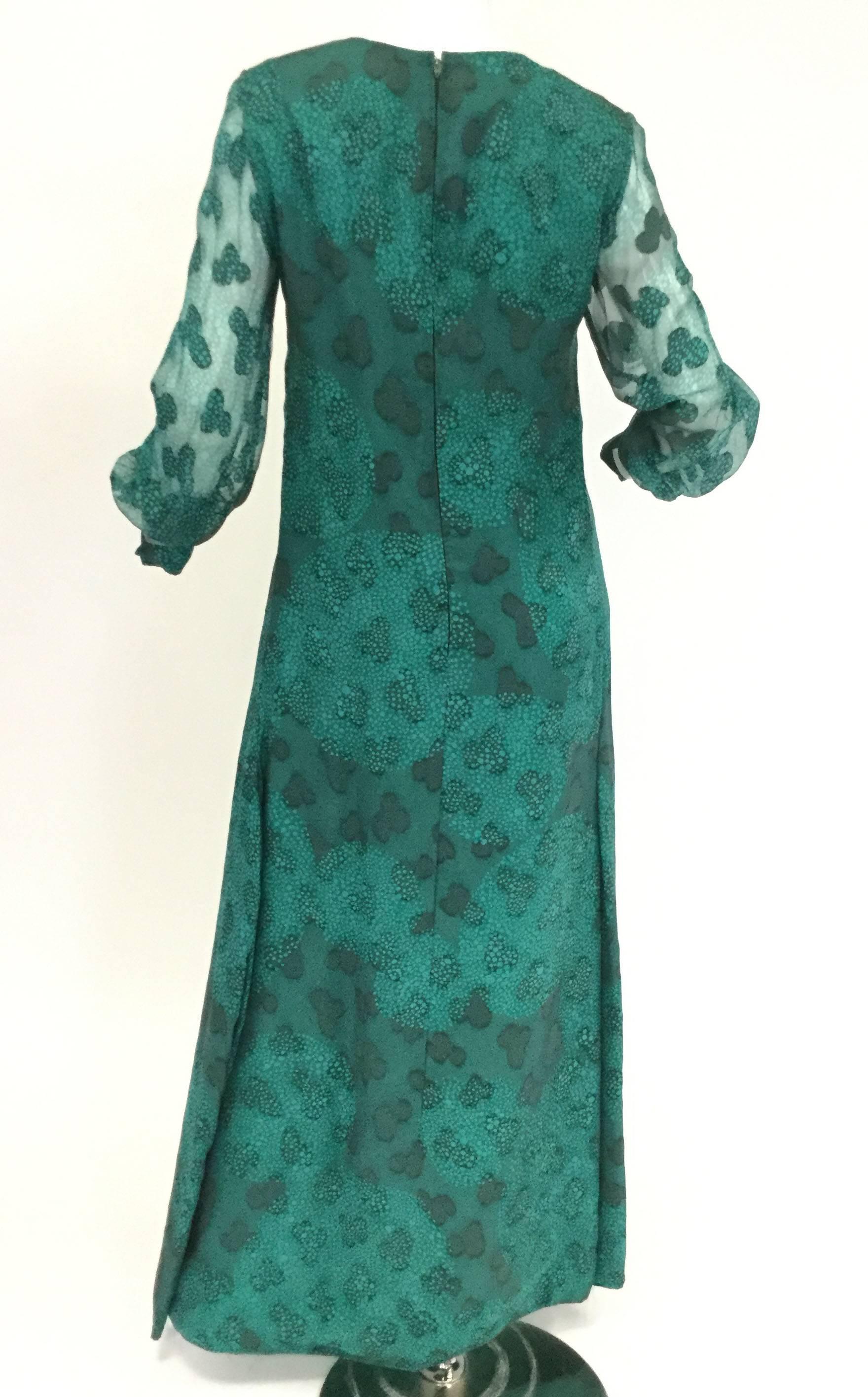 
This beautiful and fun  dress by Esther Wolf is absolutely fantastic! This maxi dress has long, sheer, voluminous, cuffed sheer bishop sleeves and a jewel neckline. The dress features a three-leaf clover and speckled dot composite overlay pattern