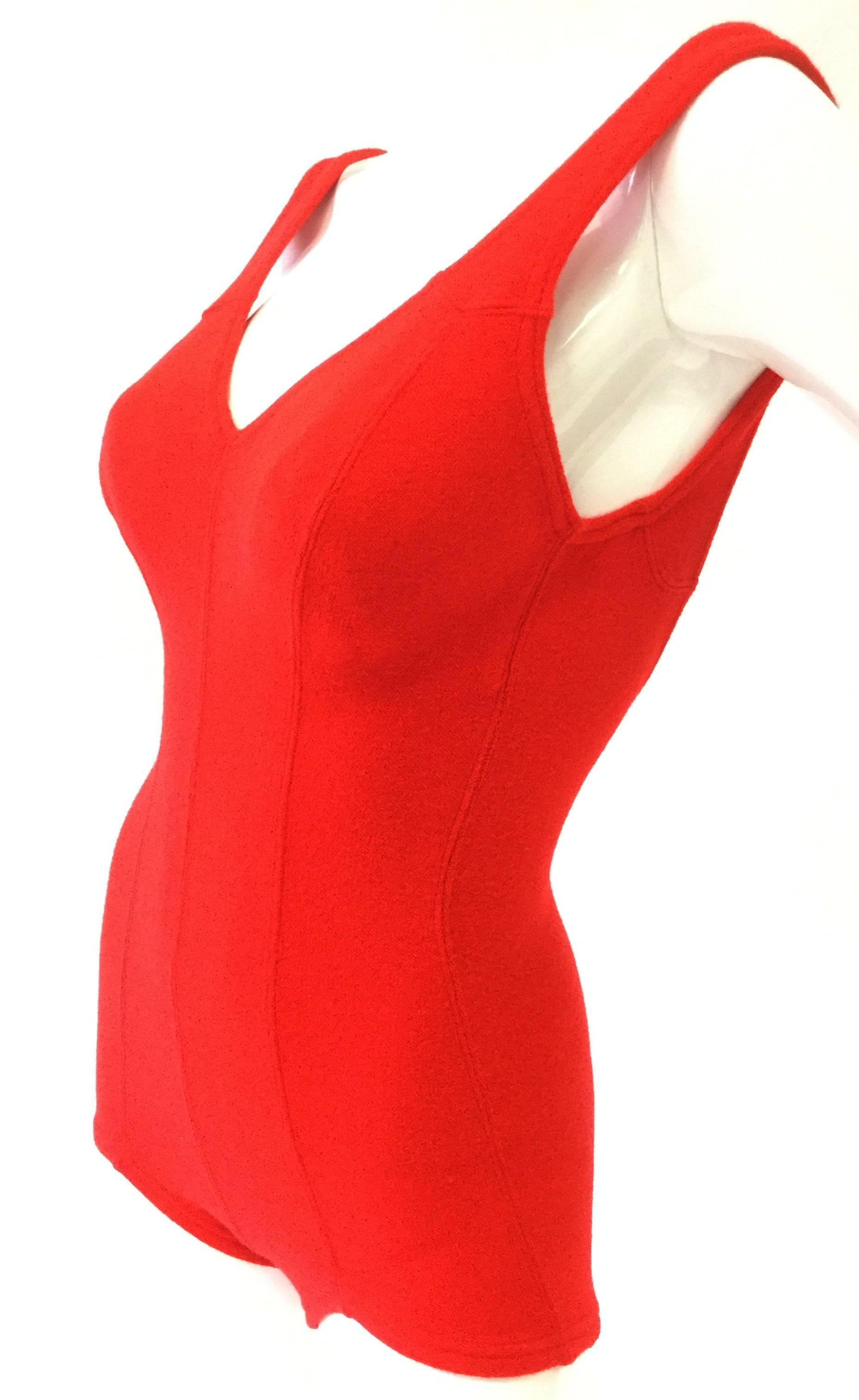 
This adorable swimsuit romper by De Weese features a striking three line seam design at the center front, created by the garment's paneled construction. The piece has a boy-short bottom, a deep v-neck collar, thick straps, and a plunging back.