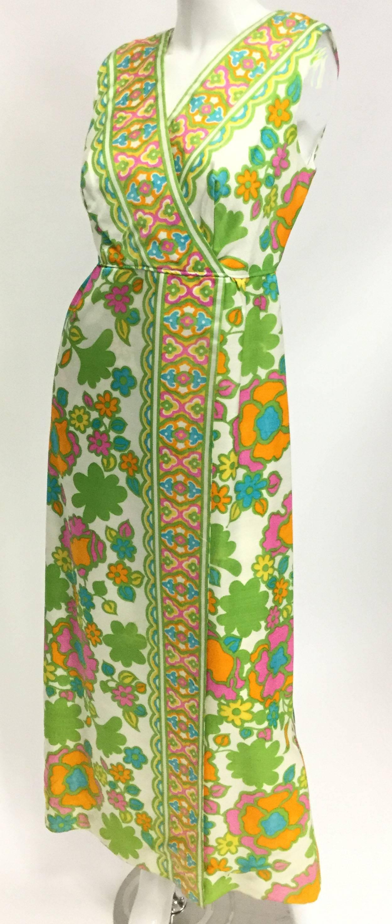 This sleeveless, ankle length dress features a V-neck front collar as well as V-neck back scoop, and a long open sheath skirt. The print features a whimsical flower print and playful geometric hem borders in a fresh combination of colors including