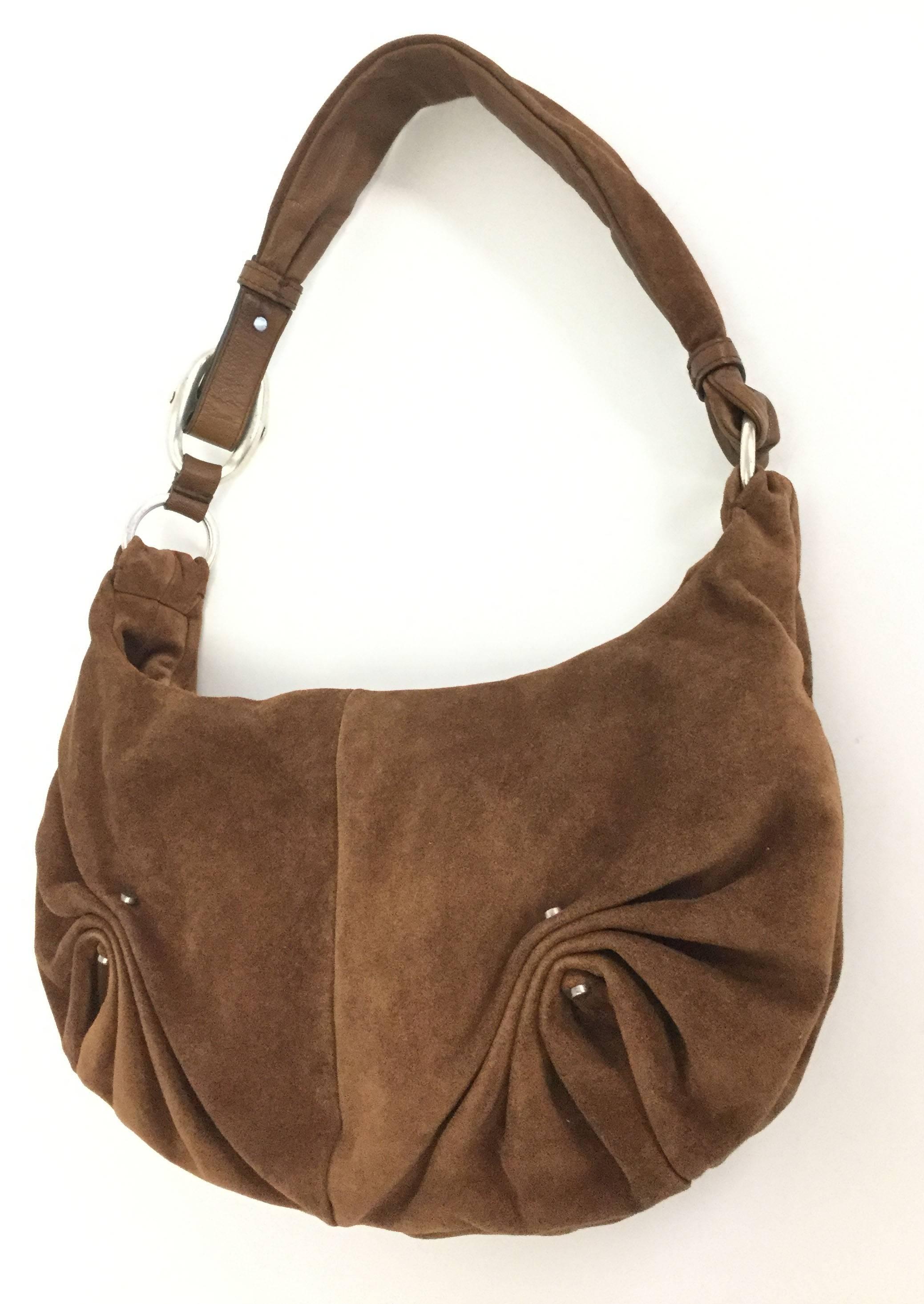 This gorgeous cocoa brown split leather suede hobo shoulder bag by Yves Saint Laurent is both sculptural and wonderfully relaxed. The smooth lambskin full grain aniline body of the purse features soft pinched pleats held together by antiqued