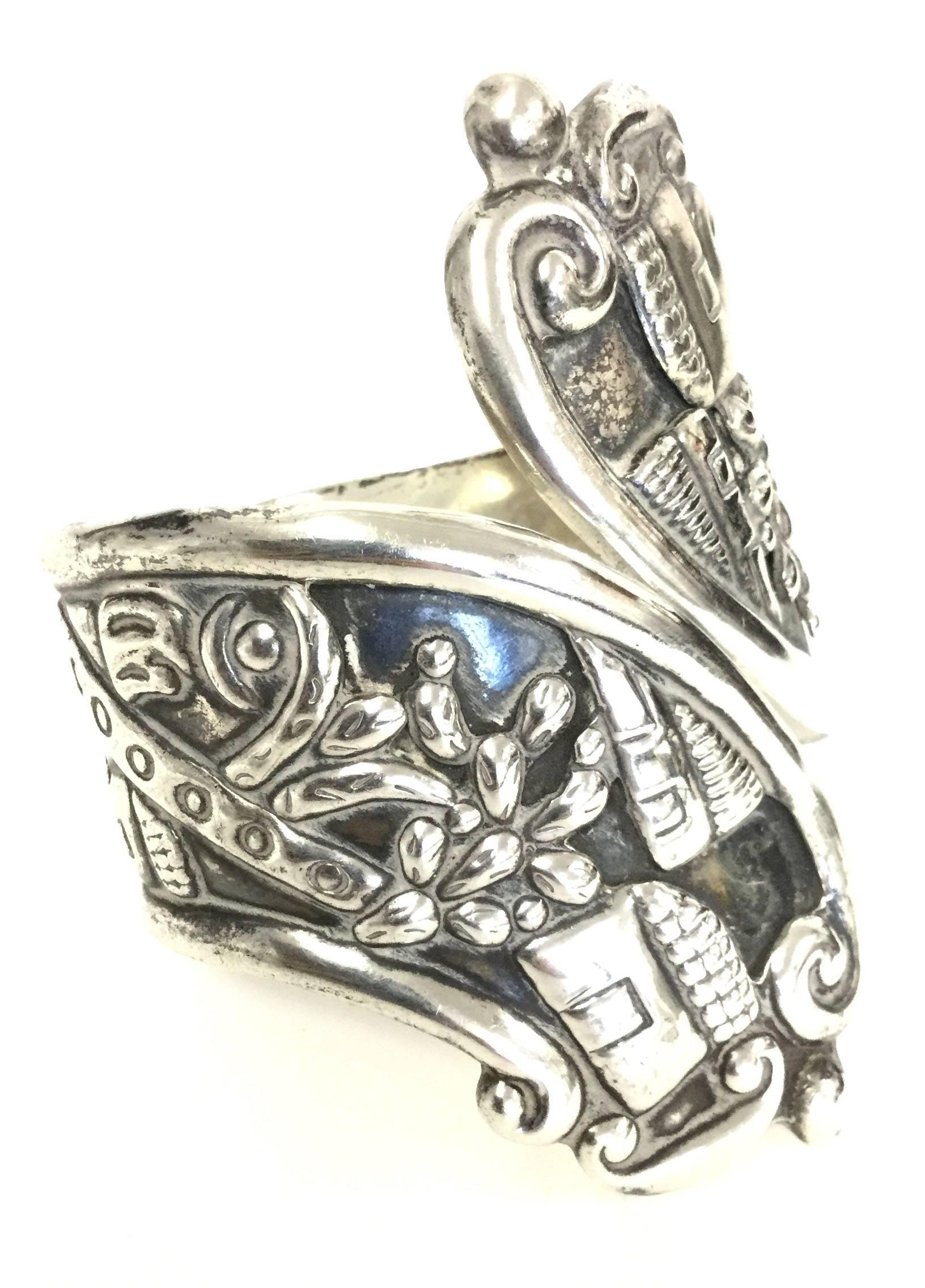 
This imaginative cuff by Alfredo Villasana of Taxco fame features a flattened perspective village scene stamped in repousse. The clamper cuff bracelet displays the figure of a man - in a poncho and hat - looking down a peaceful street lined with