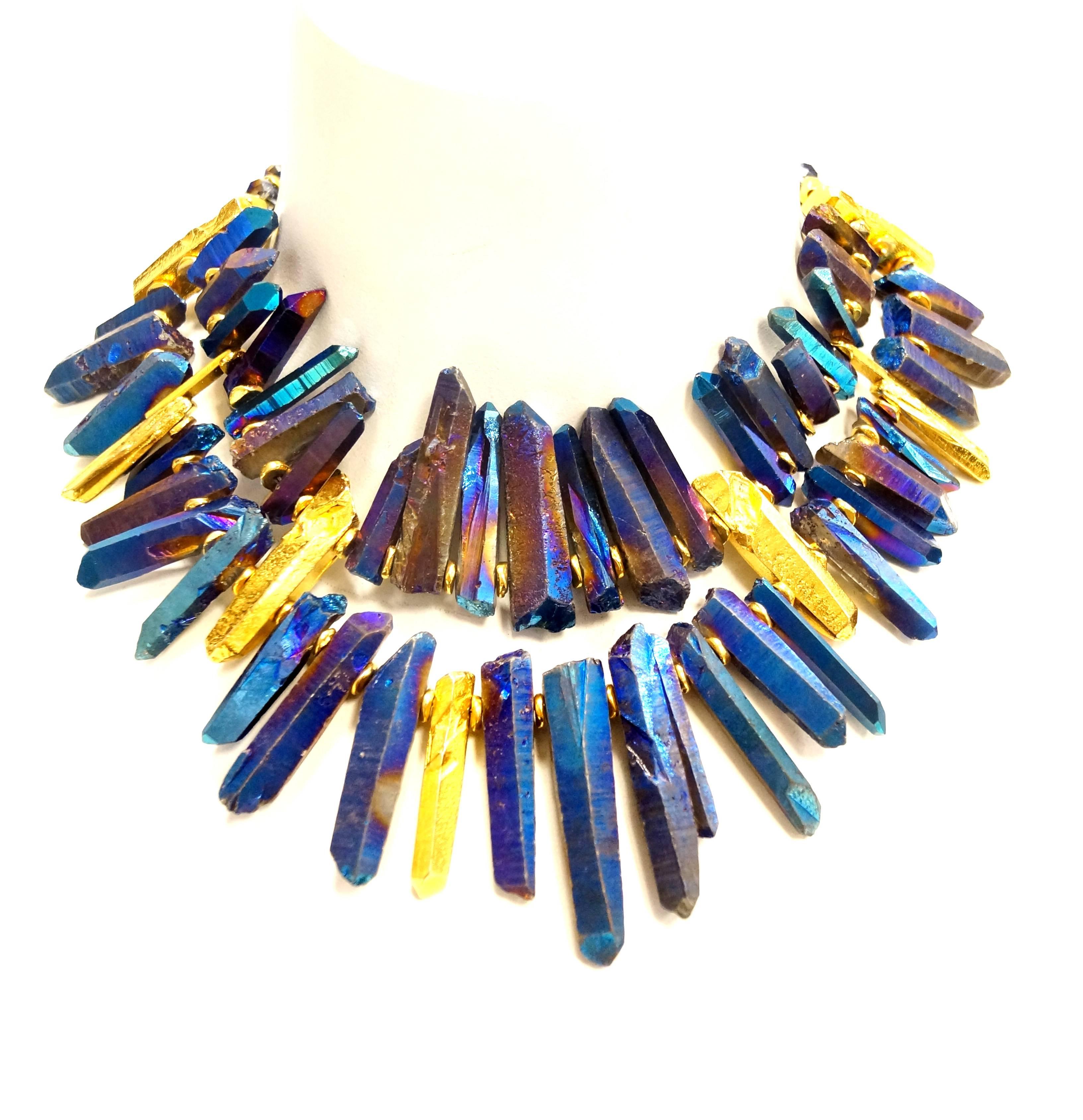 This gold and blue iridescent crystal necklace is an absolute dream! The Barrera necklace is composed of a triple strand of iridescent blue multifaceted spherical beads with gold - tone bar spacers. The triple strands give way to two strands of what