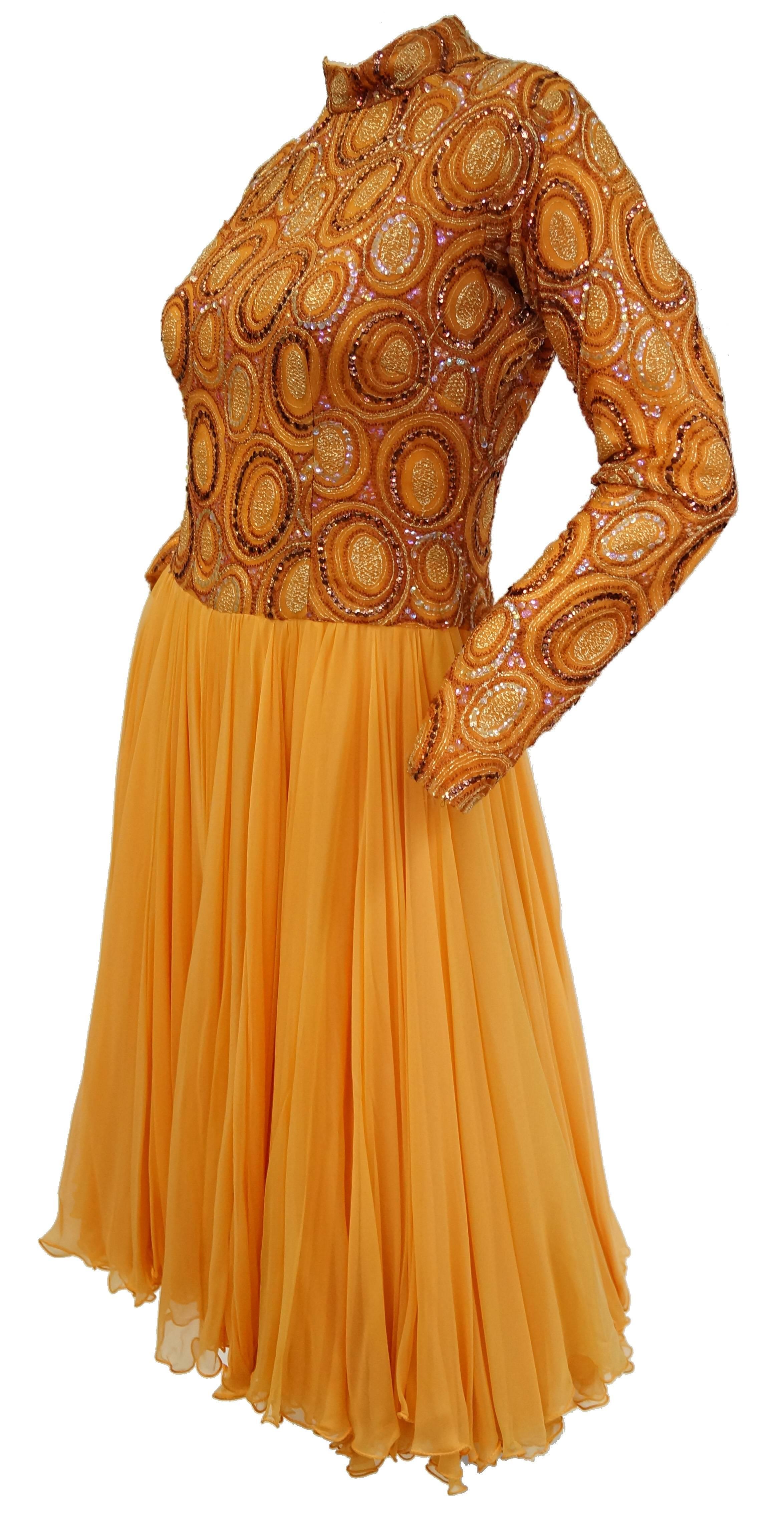 This undeniably bubbly cocktail dress features a bouncy, layered chiffon skirt with micro pleats, and an eye catching bubble sequined bodice and sleeves in iridescent amber, violet, and pearl. The knee length dress has long sleeves and a turtleneck