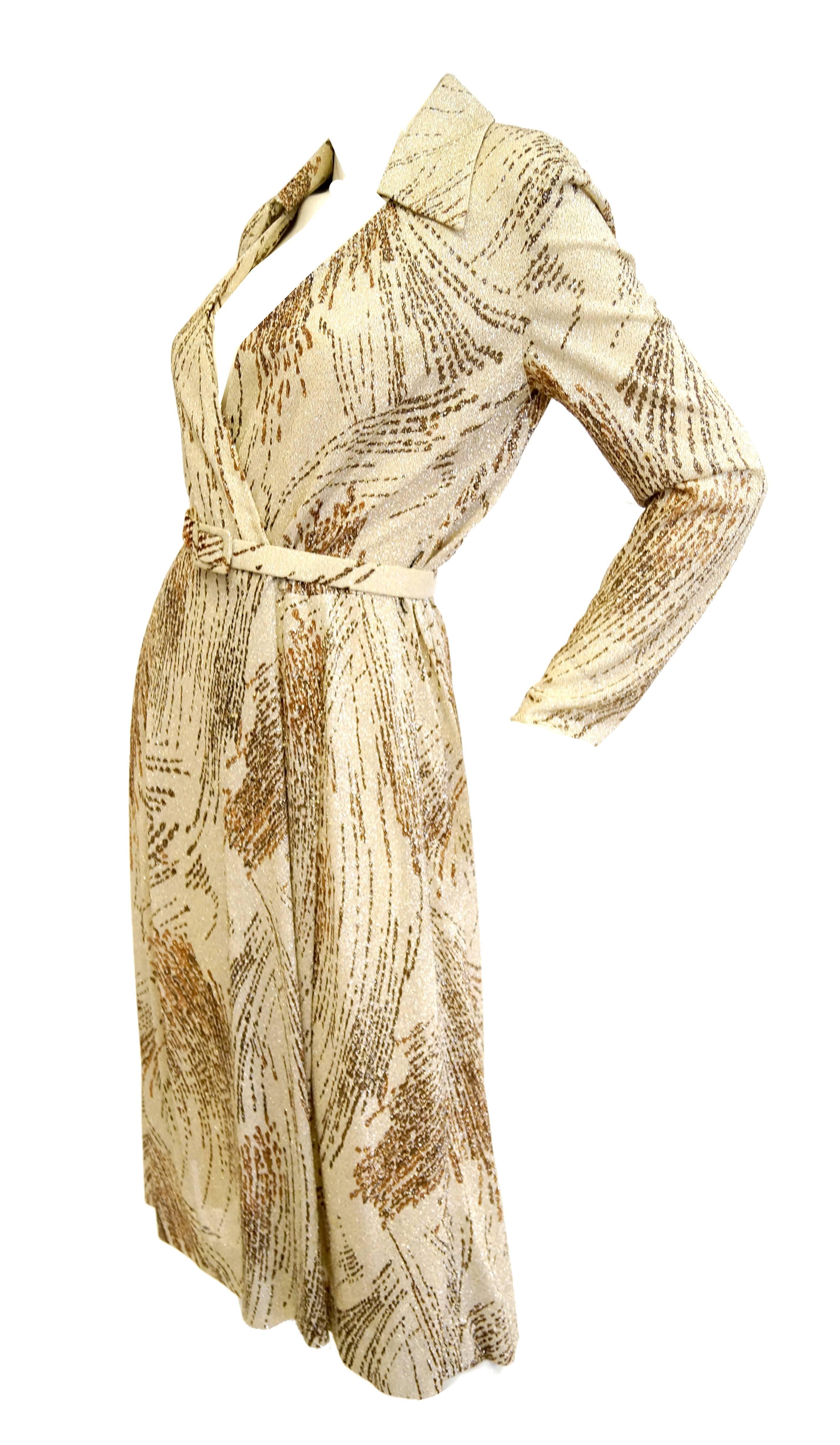 This gorgeous knit dress by Adele Simpson is wildly streaked with shimmering metallic thread marks reminiscent of the tail end of a comet, or the paint splatter of a Pollock! The wrap dress is midi length, features long sleeves, and a wing collar.