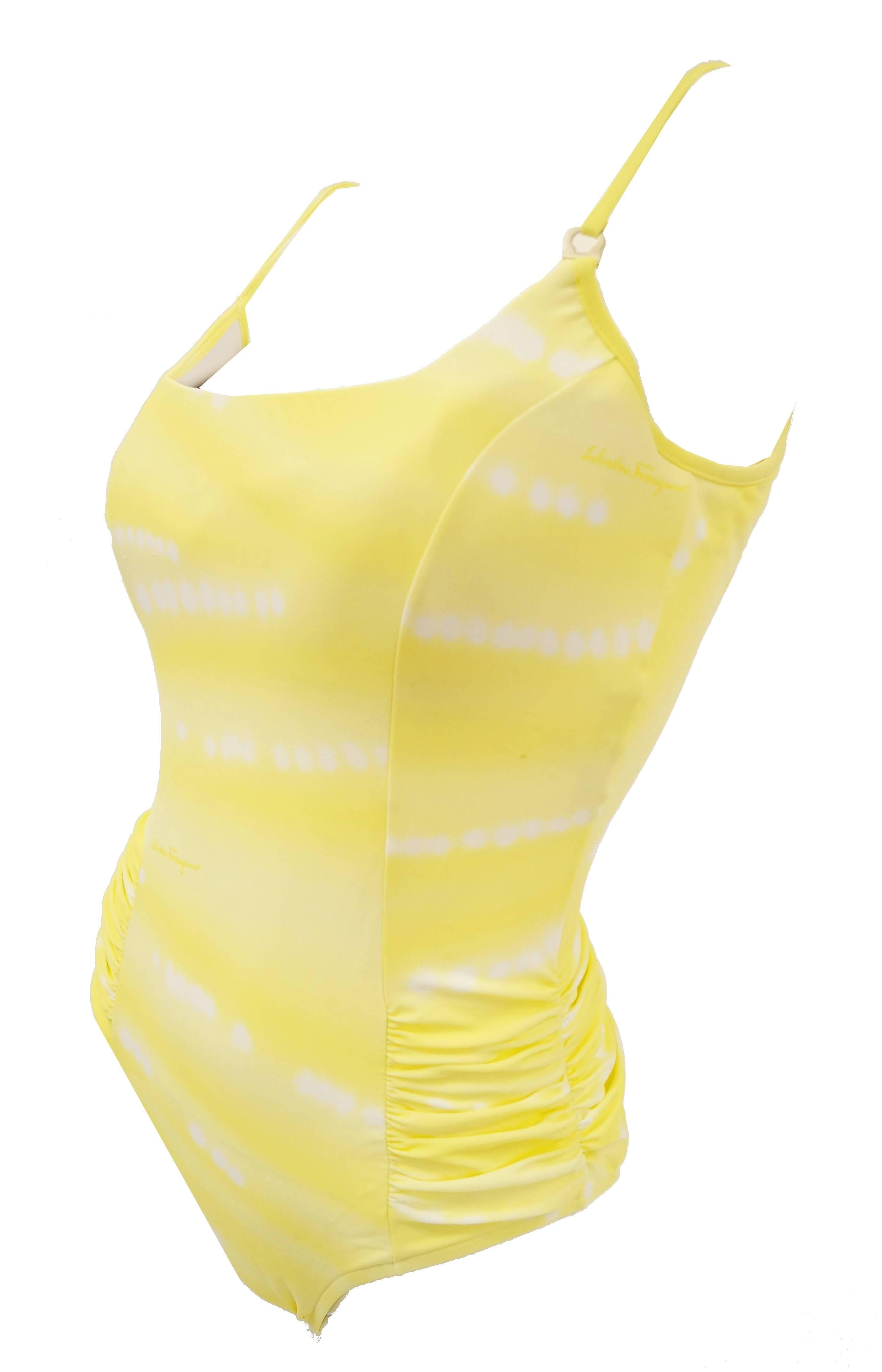 Beat the heat in this cool yellow fold dyed swimsuit by Ferragamo. The swimsuit features minute ruching on both hips, a low scoop back, and a scoop collar with a Ferragamo horseshoe charm on one strap. The swimsuit comes with a cute and convenient