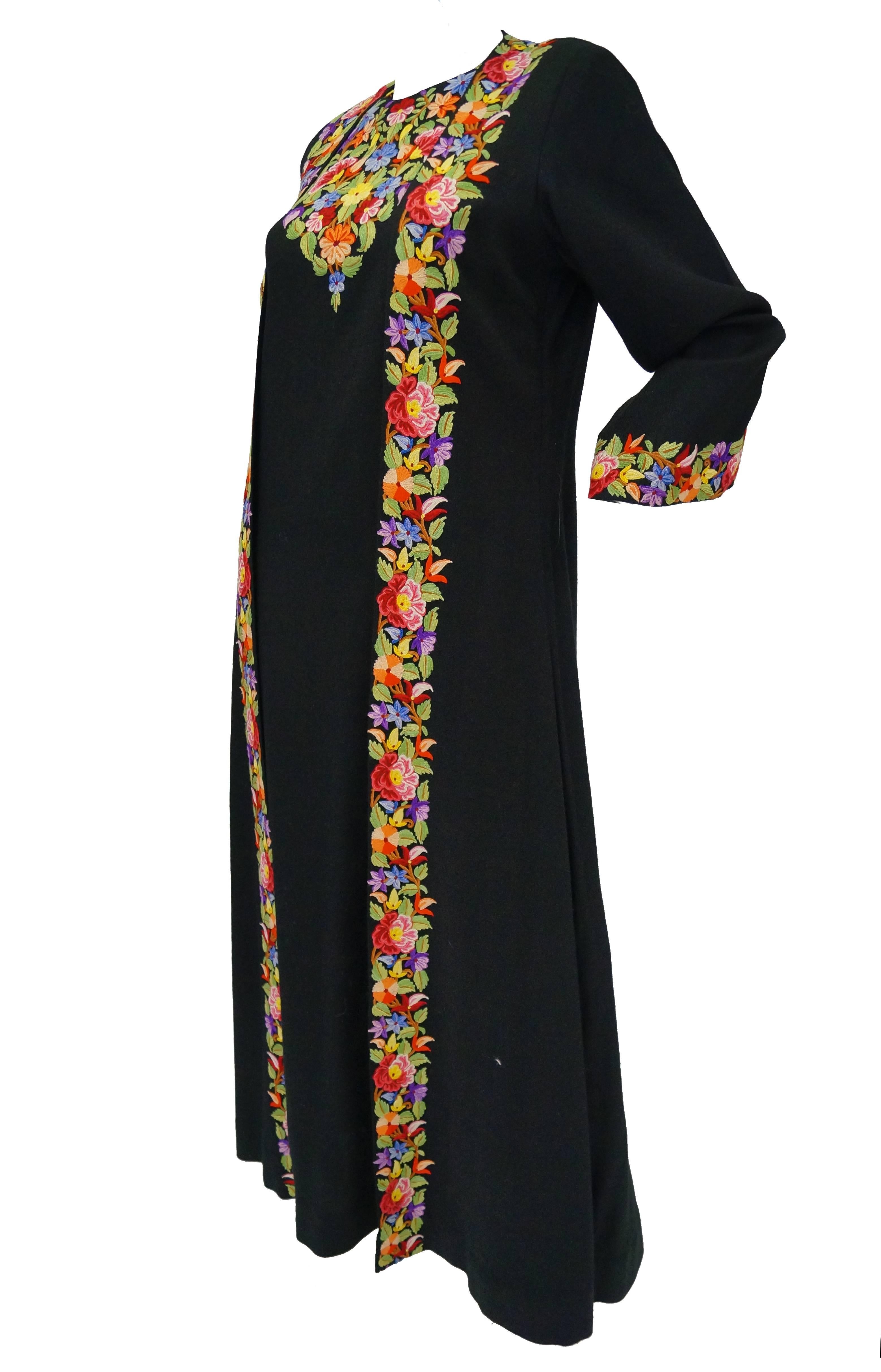 Colorful one piece full length wrap dress coat featured at the famous "Suffering Moses" boutique known for curating all forms of artisan created wares, including works of crewel textiles.  

The dress coat features an elaborate, fully