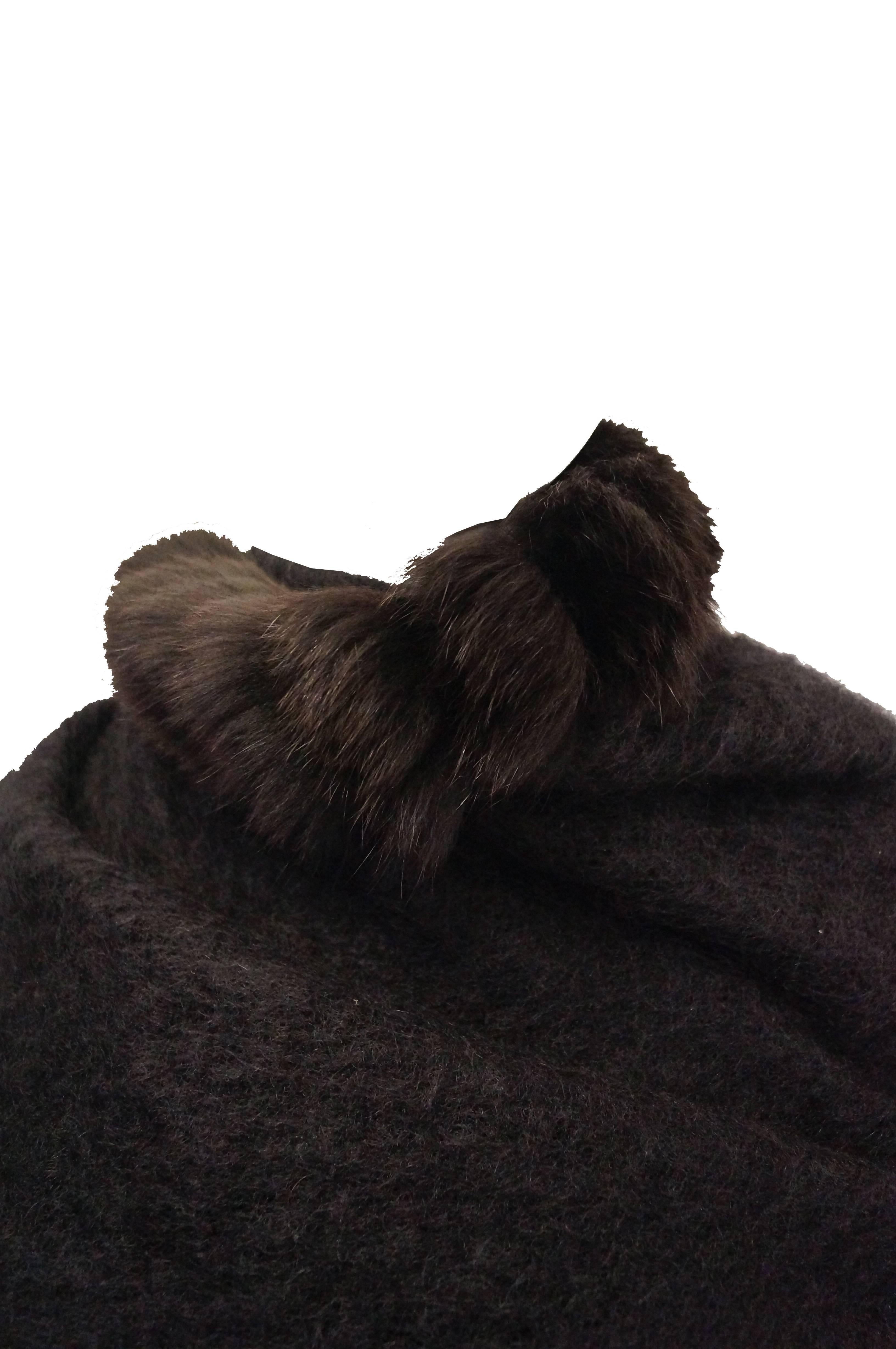 This shawl by Yves Saint Laurent is made of a plush loose knit wool and features long tufts of espresso brown fox fur edging as well as glossy button details. The triangular shawl is large enough to fully wrap around the shoulders and neck, and can