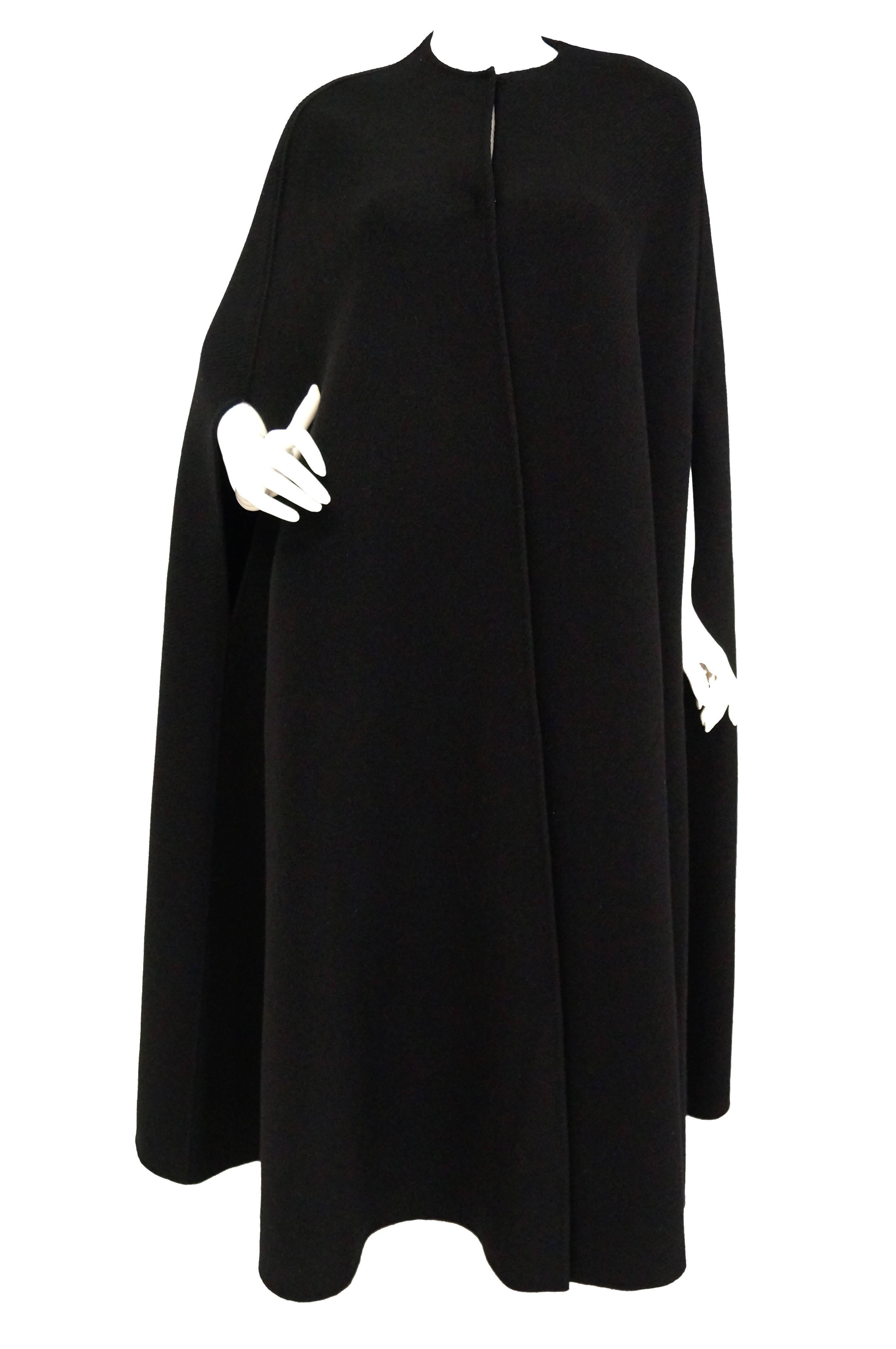 Madame Gres, was a genius and could could create gorgeous designs under even the most strict limitations. The gorgeous cloak is made of black wool, and features a rounded neckline as well as slits for arms. The wool is heavy, with strong, precise