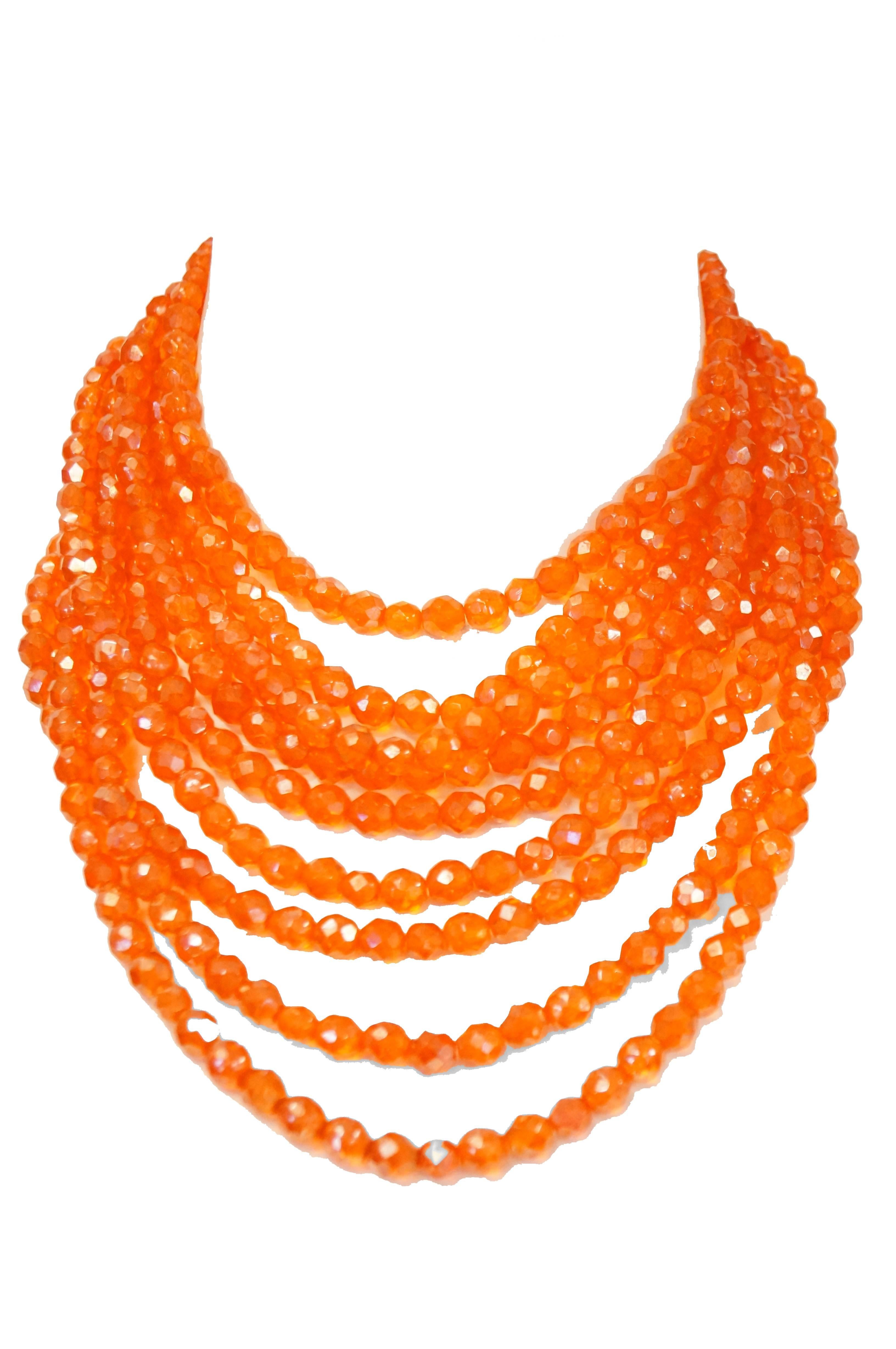 Fabulous multistrand orange necklace by Coppola e Toppo! The necklace is composed of nine separate strands of beads brought together at the ends by the decorated clasp. The clasps of the necklace are composed of a triangular bronze base decorated by