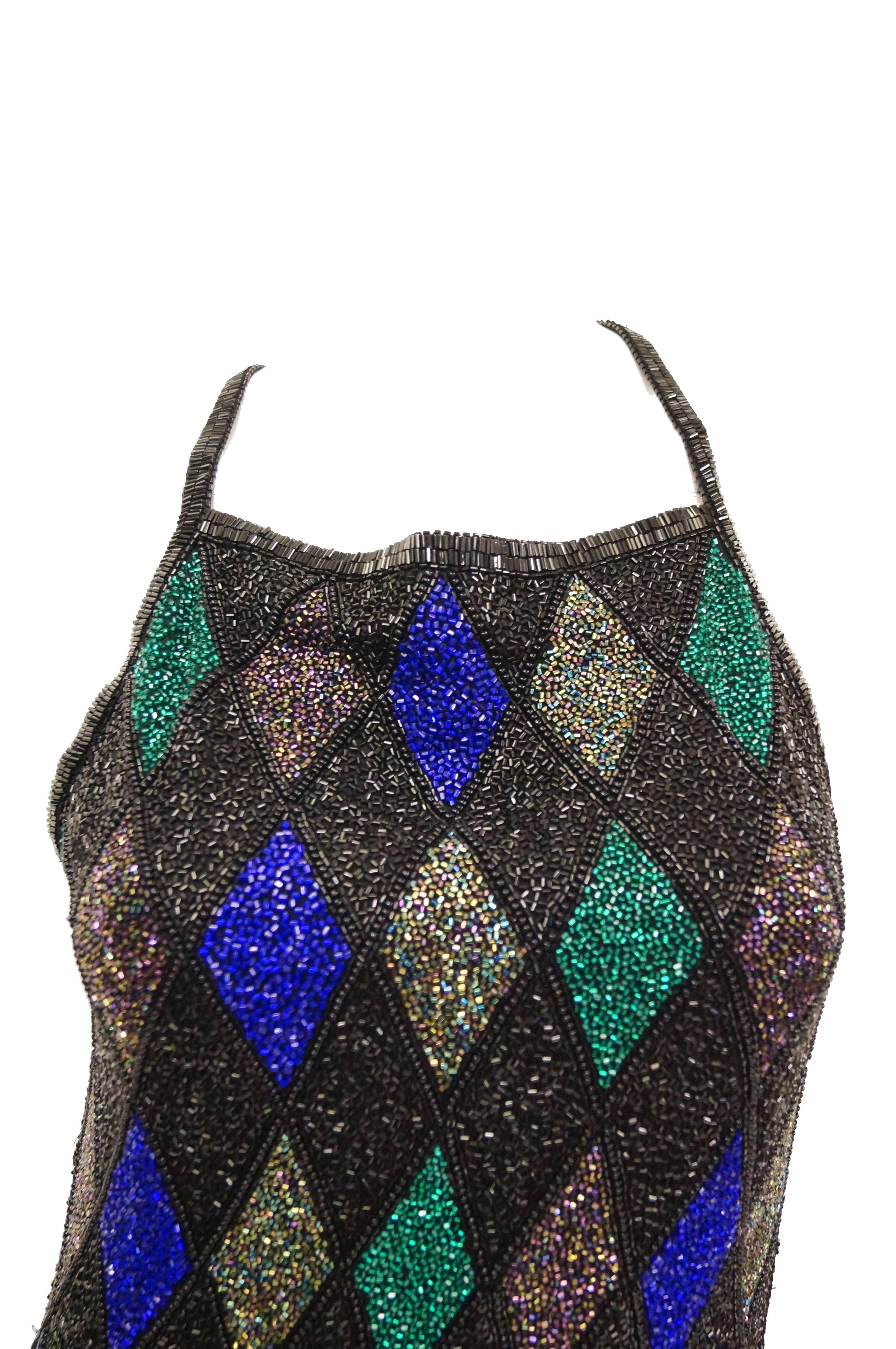 This dress hits mid thigh, has a halter neckline with criss - cross straps connecting to a plunging, low - cut back. The dress is meticulously beaded in a diamond pattern, with cobalt blue, lime green, and dark mauve beads between shimmering black