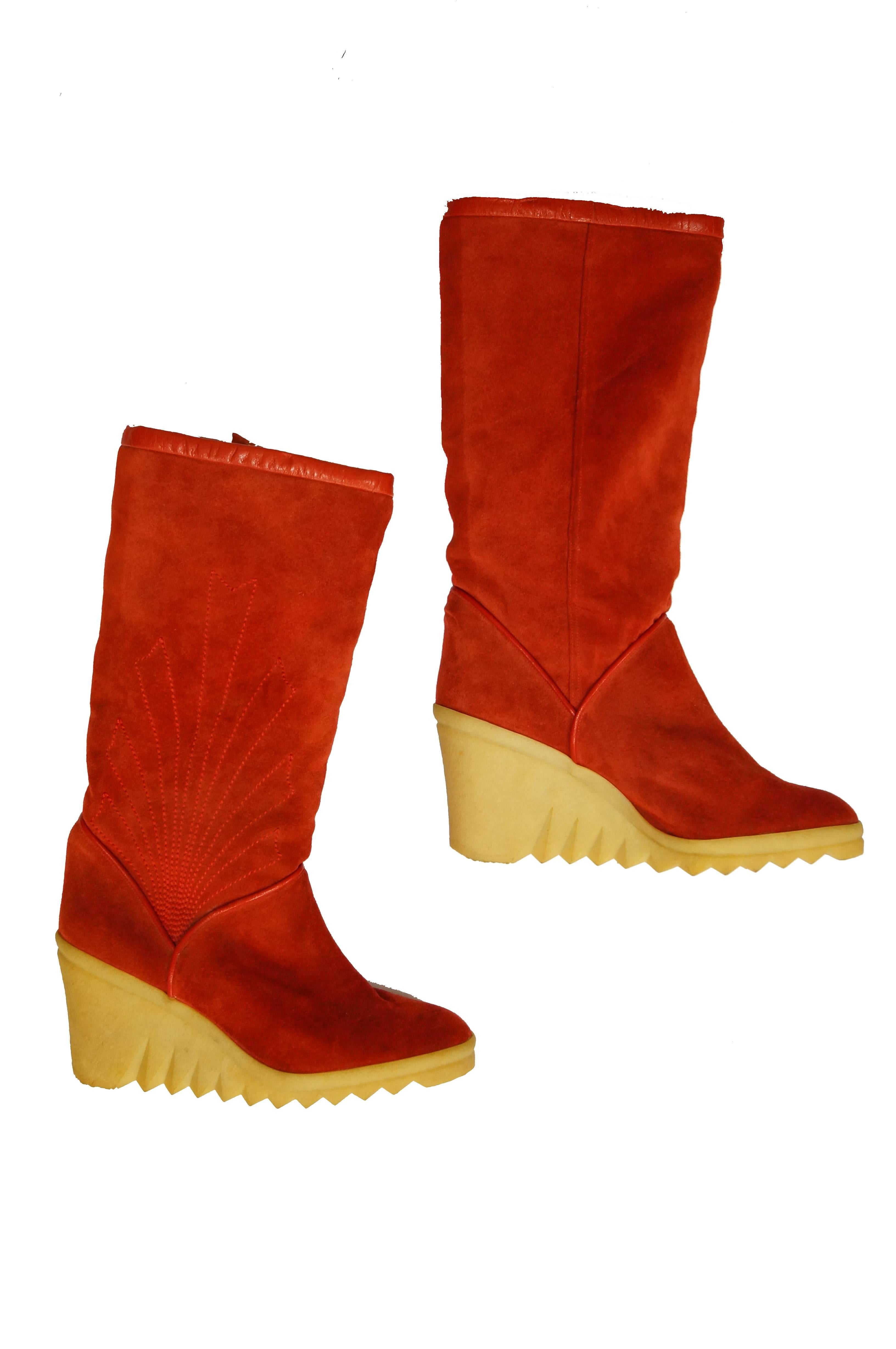 1970's Wedge boots by Charles Jourdan featuring a cherry red suede and natural rubber heels. The boots have a tall zig - zag tread, red trim at the top, and a wonderful sunrise - like stitch detail on the outer panels.  Climb a mountain - or climb