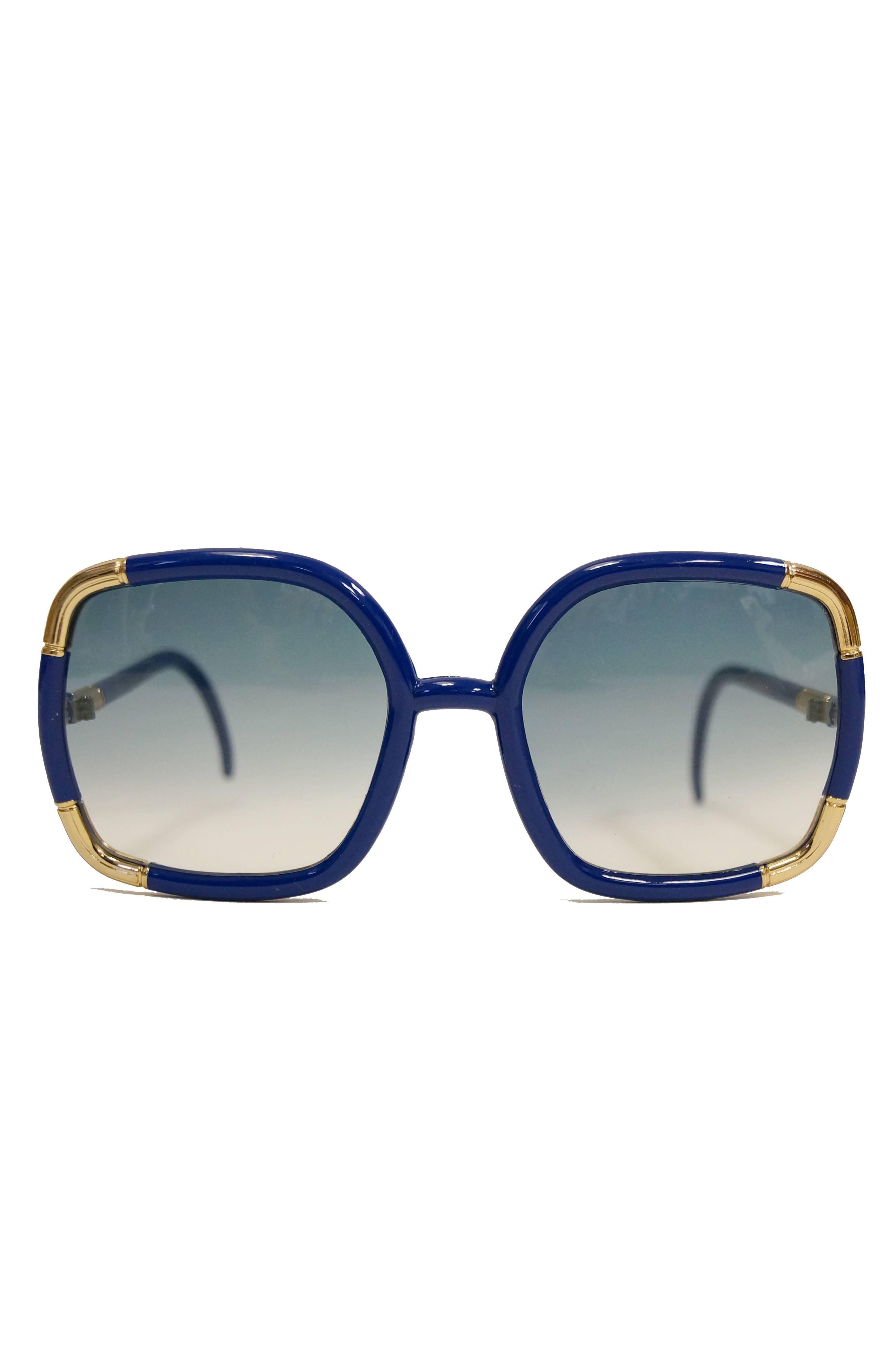 1970s Ted Lapidus Paris sunglasses. These playful and vibrant oversized sunglasses are square-shaped (with a gentle rounded edge!) and feature blue single bridge frames (with fantastic gold-tone accents!). The lenses have a solid blue tint, and the