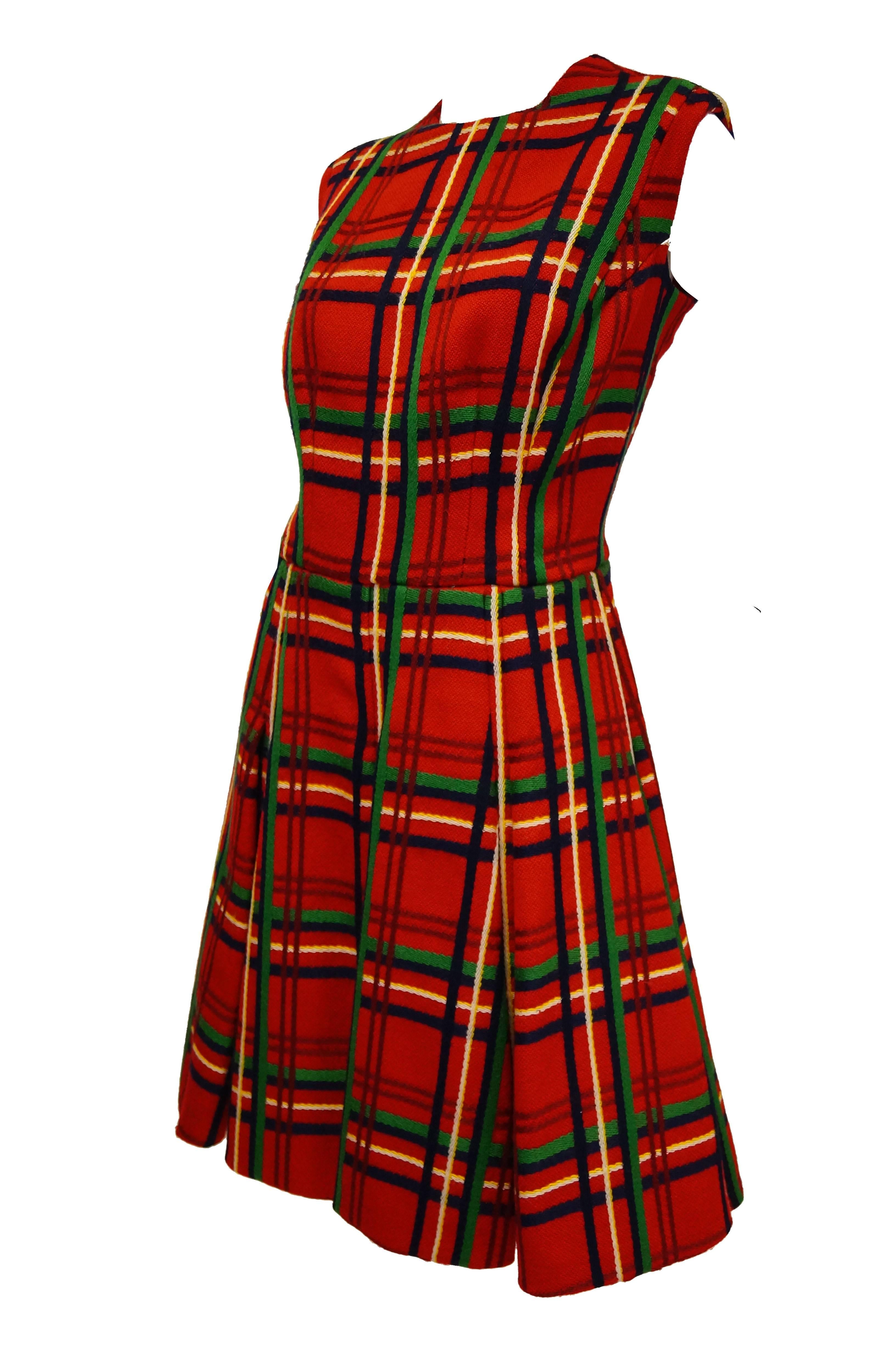 Rich wool and pristine technique and excuation are almost as noticeable as bold colors of red, green, navy, and yellow plaid dress and jacket by Galanos!  This ensemble includes a fit and flare a - line dress with pleated skirt, no sleeves, and a