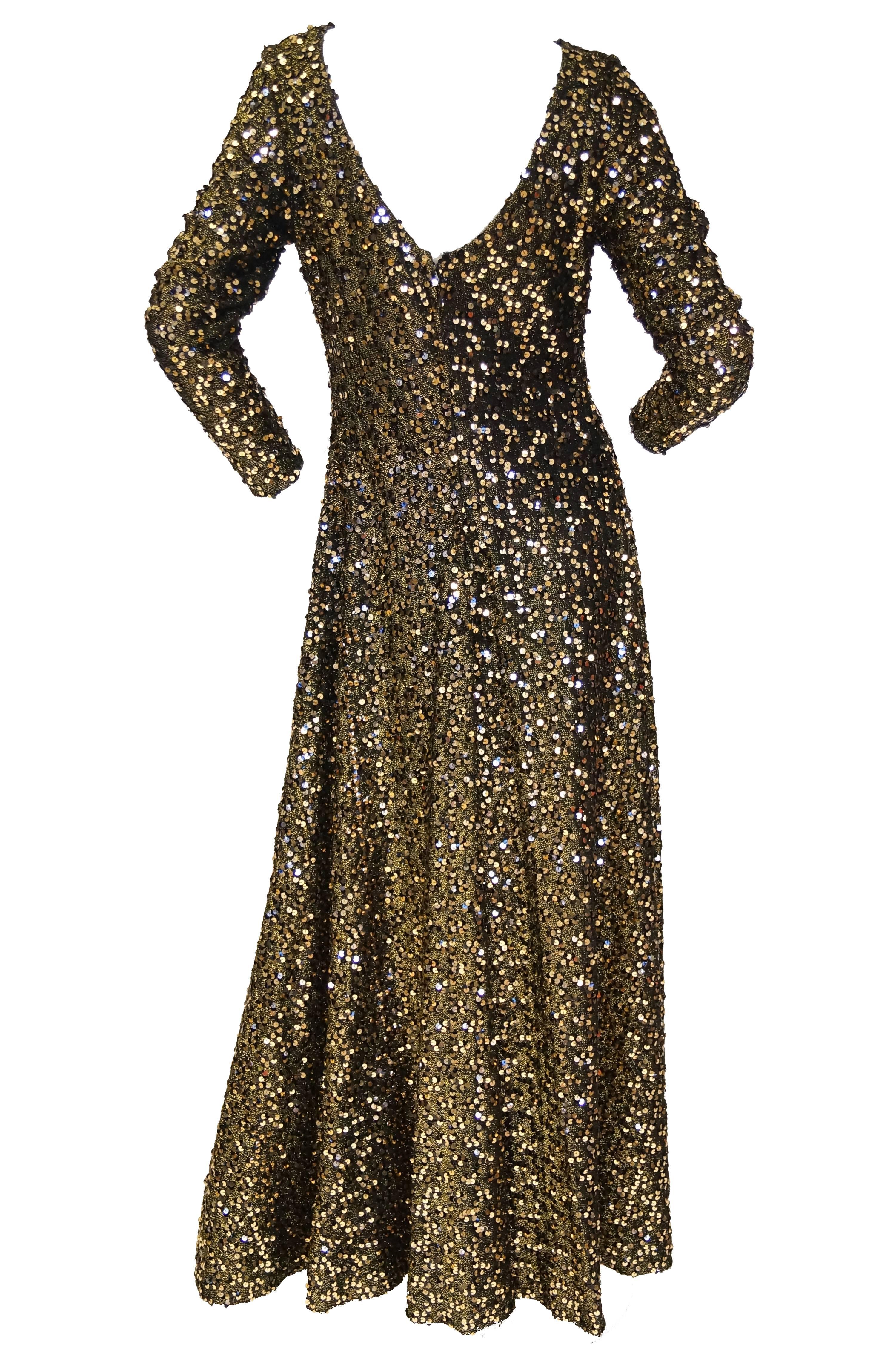Floor length maxi black and gold sequin evening dress by Jill Richards. The dress has long sleeves, a loose waist and voluminous skirt that pools slightly at the bottom. The dress has a low back that reaches mid back. The fabulous, elegant dress is
