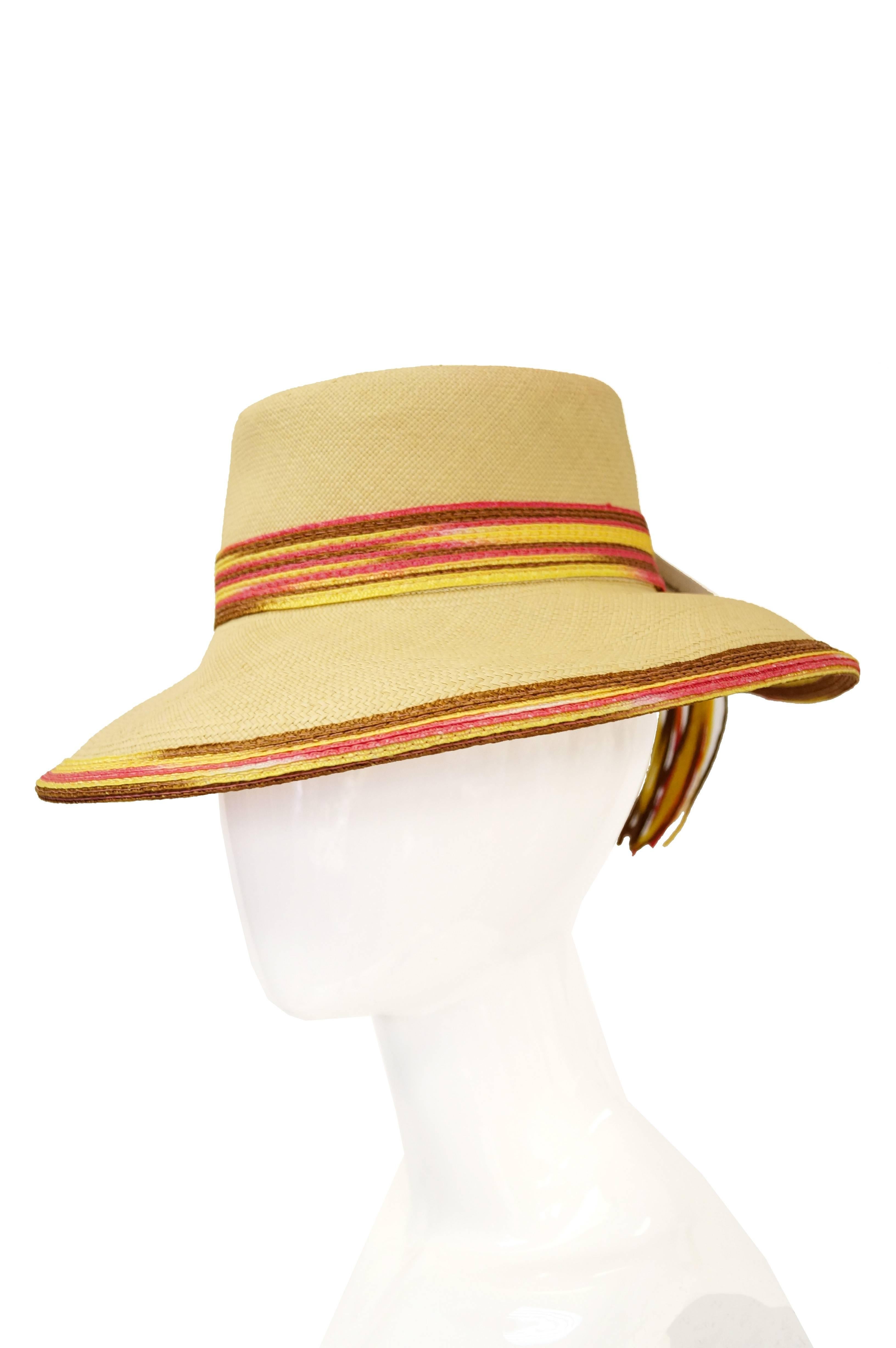 Playful and timeless sun hat by Yves Saint Laurent is perfect for your a weekend at the beach or just keeping your face out of the sun. 

The woven hat features a sandy yellow upper with colorful pink and brown edges and trim. The back of the hat is