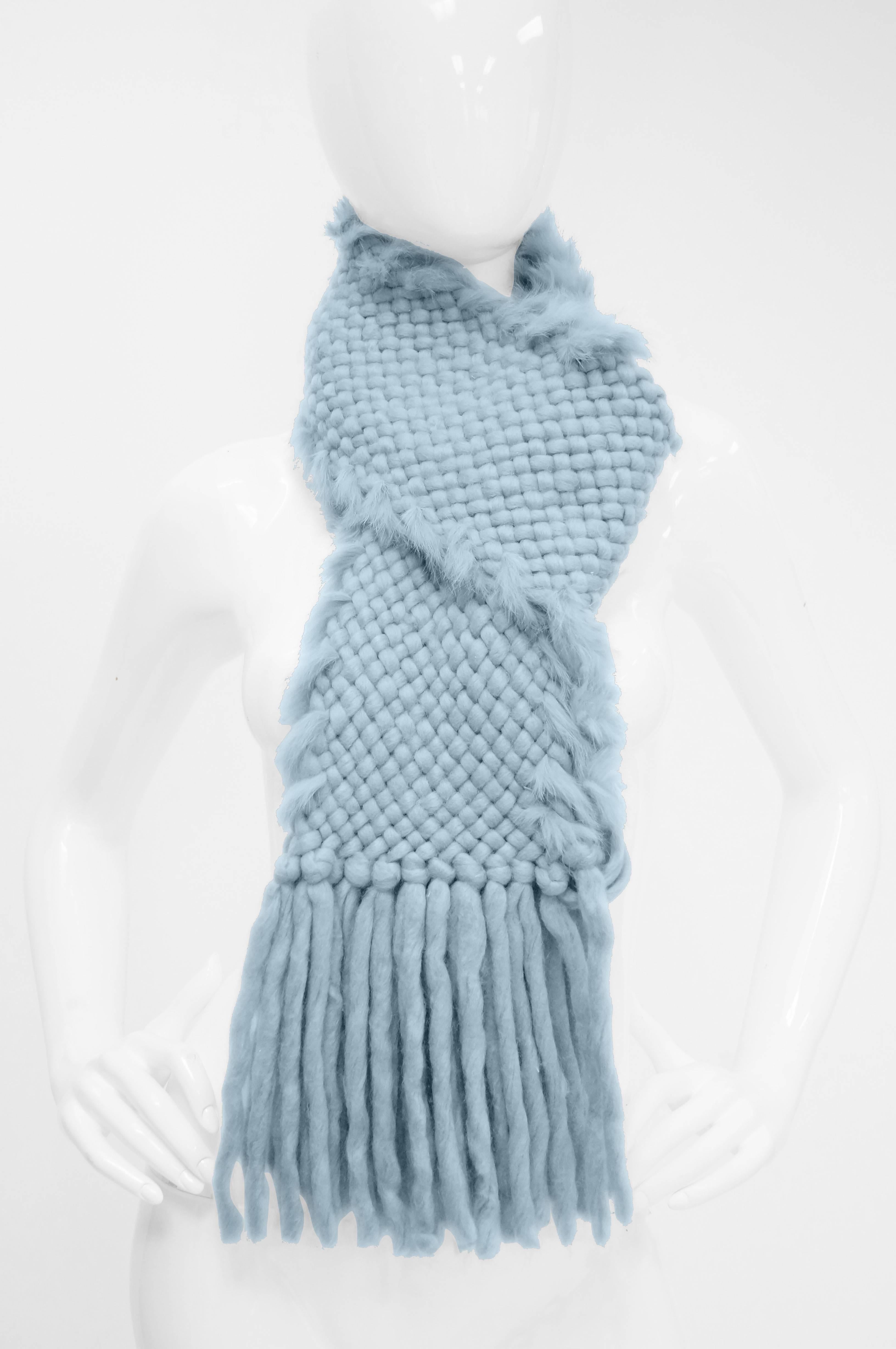 Fabulous soft basket woven angora wool blend scarf with fur trim. The long scarf has fringe at the end, and features fur strips trimming the longer edges of the scarf in a spiral - like design. Let this sky blue scarf cheer you up during the gray