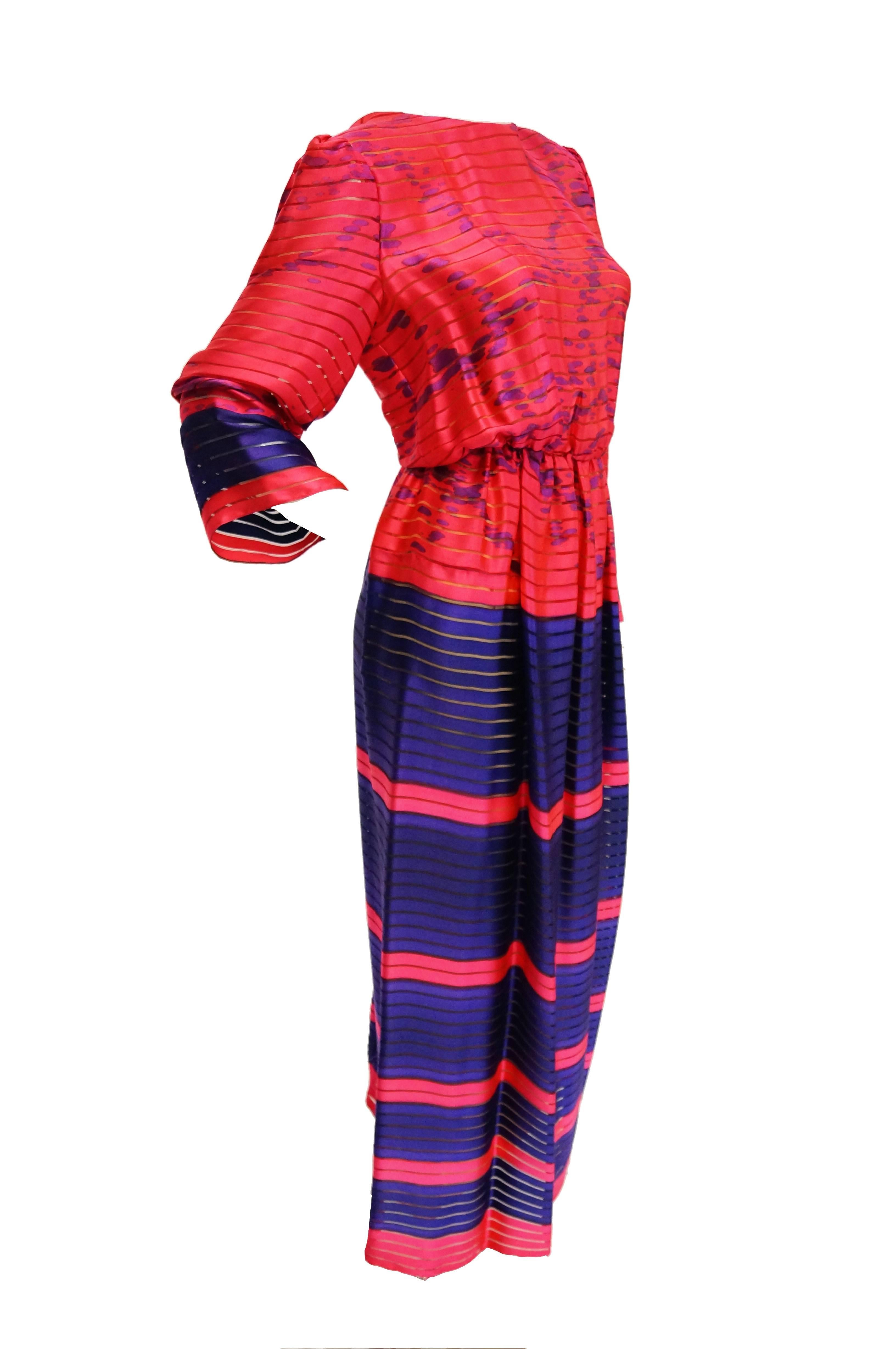 Absolutely striking bright, neon pink and purple dress by Bill Blass. The dress is maxi floor length, has long sleeves, and a round jewel collar. The dress has a pinched blouson waist and a keyhole opening with button at the back of the neck. The