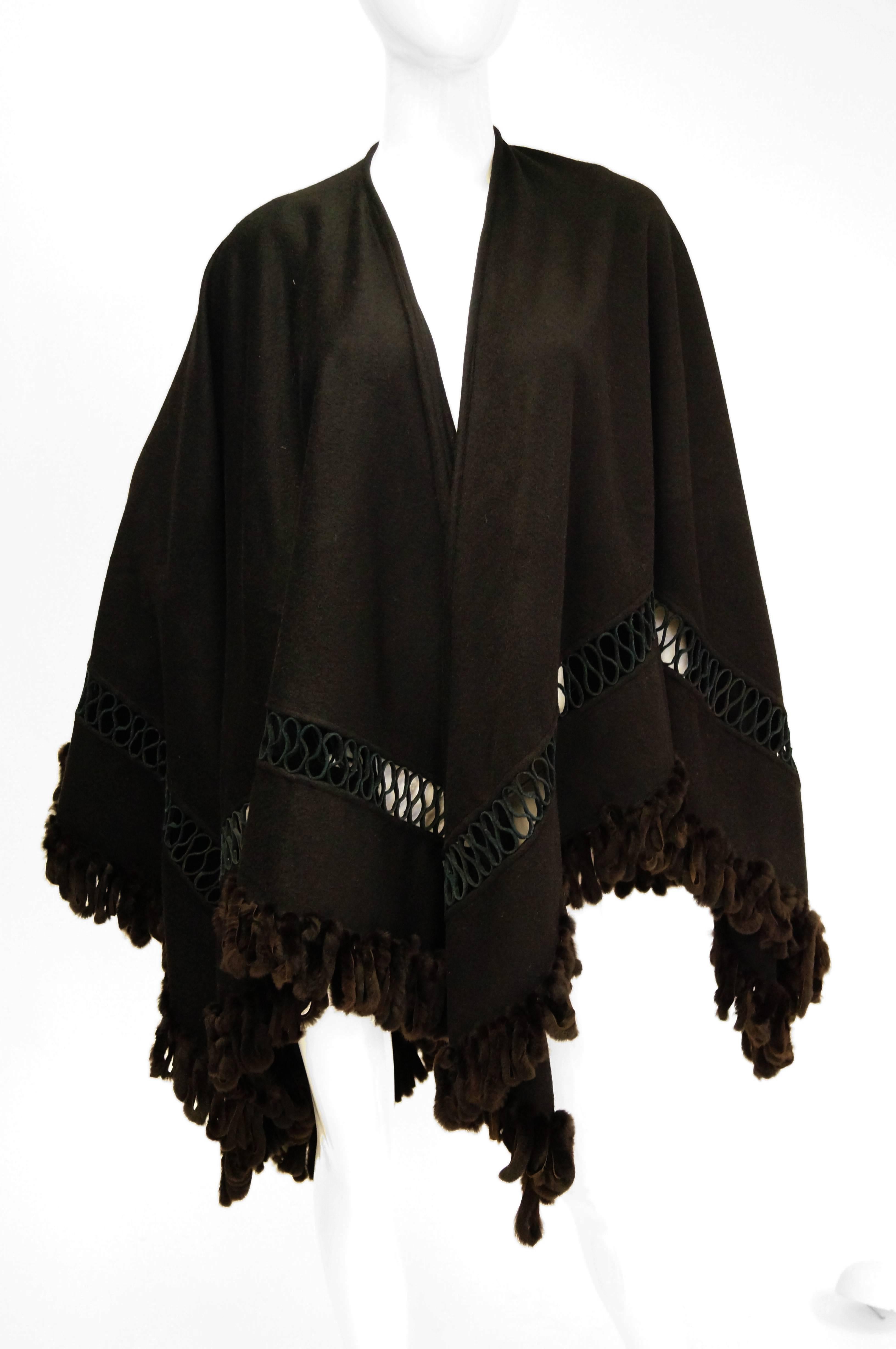 Fabulous intricate wool and fur shawl by Adrienne Landau. This solid black shawl by Adrienne Landau is diamond cut with a straight center line up to the neck. The shawl is made of a medium-weight wool that is weighed down with a fox fur tassel trim.