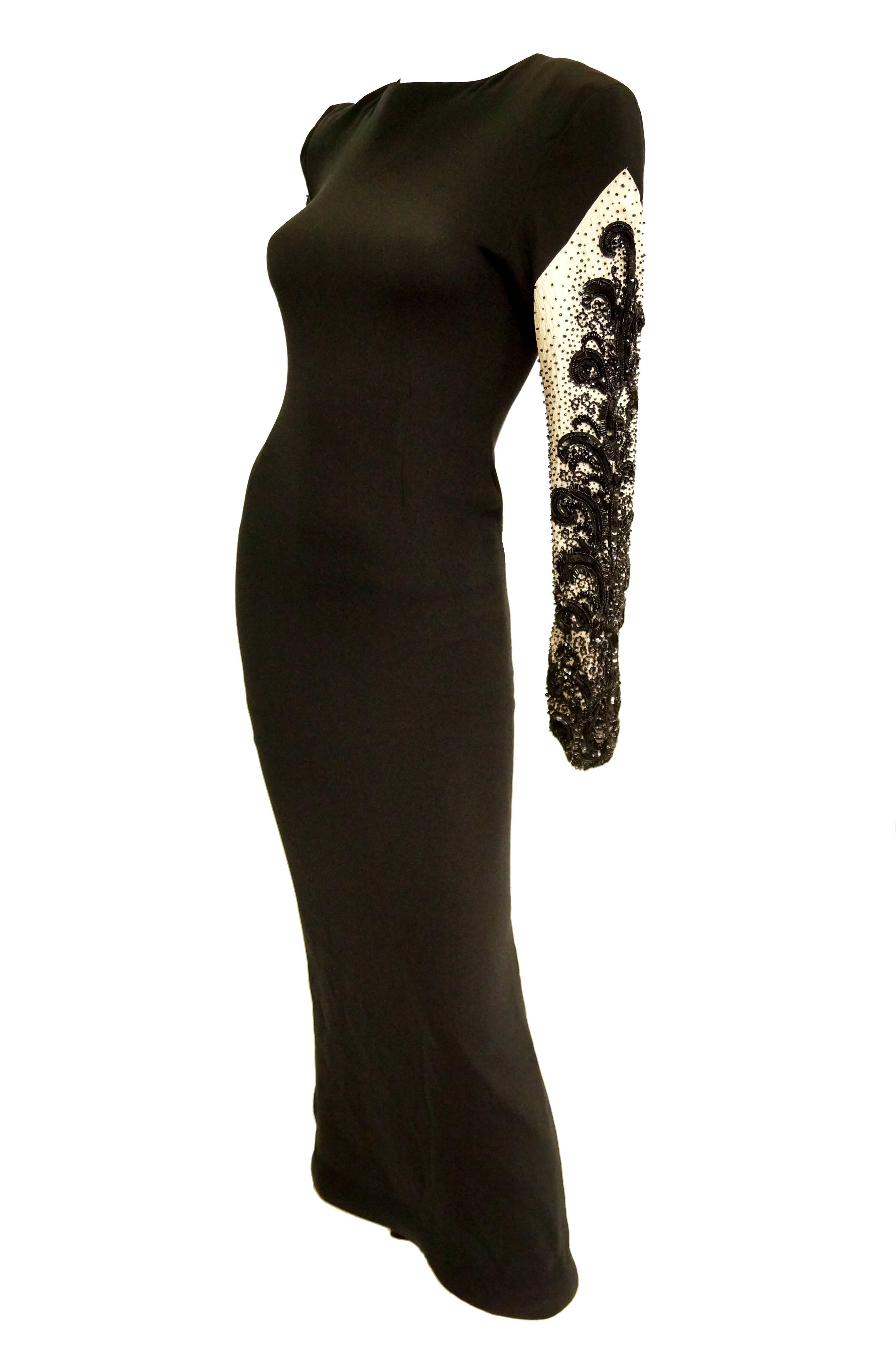 Gorgeous, heavily beaded Bill Blass evening dress. Form fitting floor length maxi dress with wide jewel neckline and long sleeves. The dress is primarily black, save for contrasting sleeves in a lightly crinkled white fabric. The sleeves are heavily