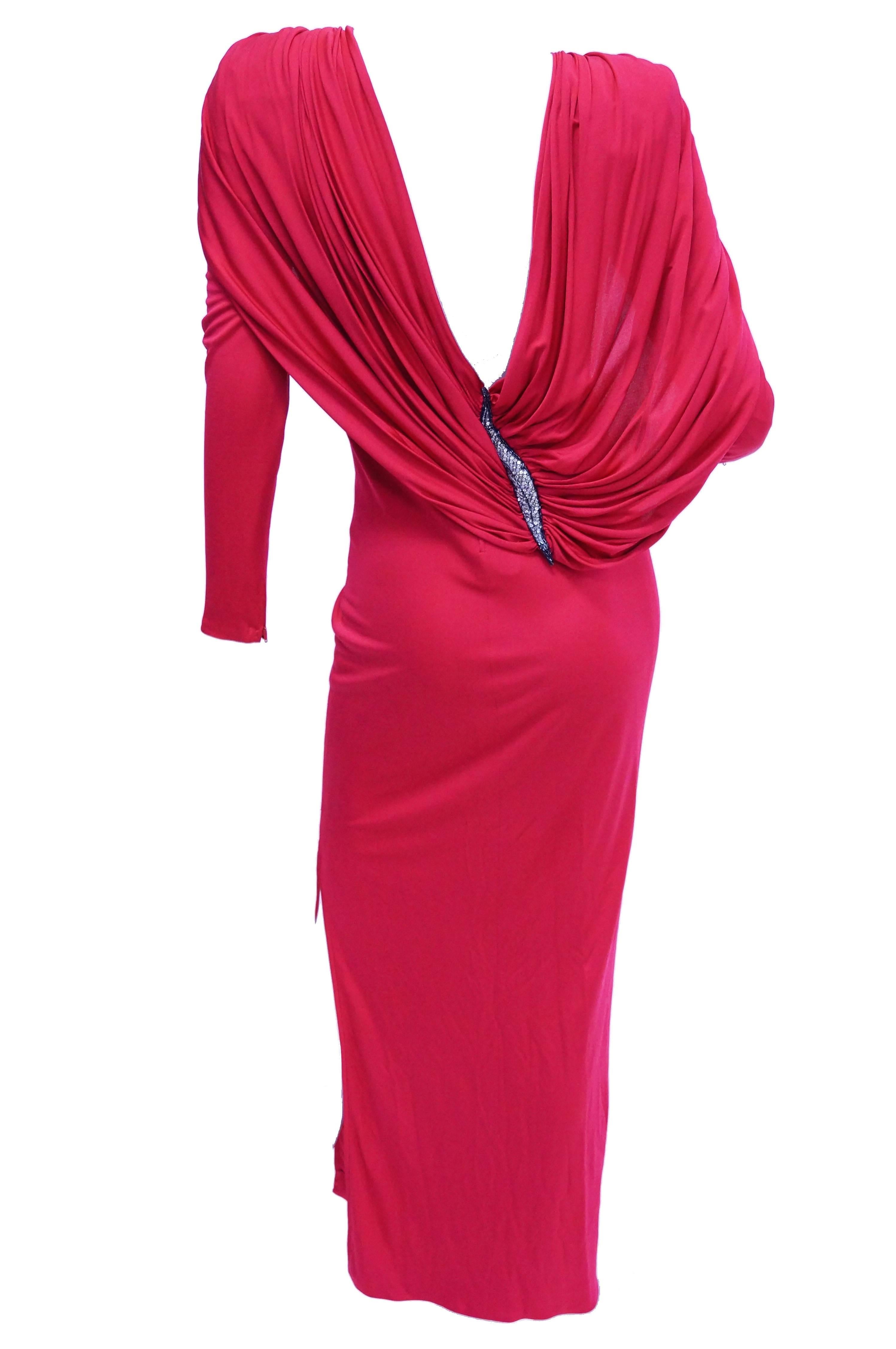 Amazing hot pink maxi length evening dress by Valentino with plunging back AND cape detail. The silk dress has long sleeves and jewel neckline, as well as a slit on the left leg that reaches just below the knee. The most prominent detail of the