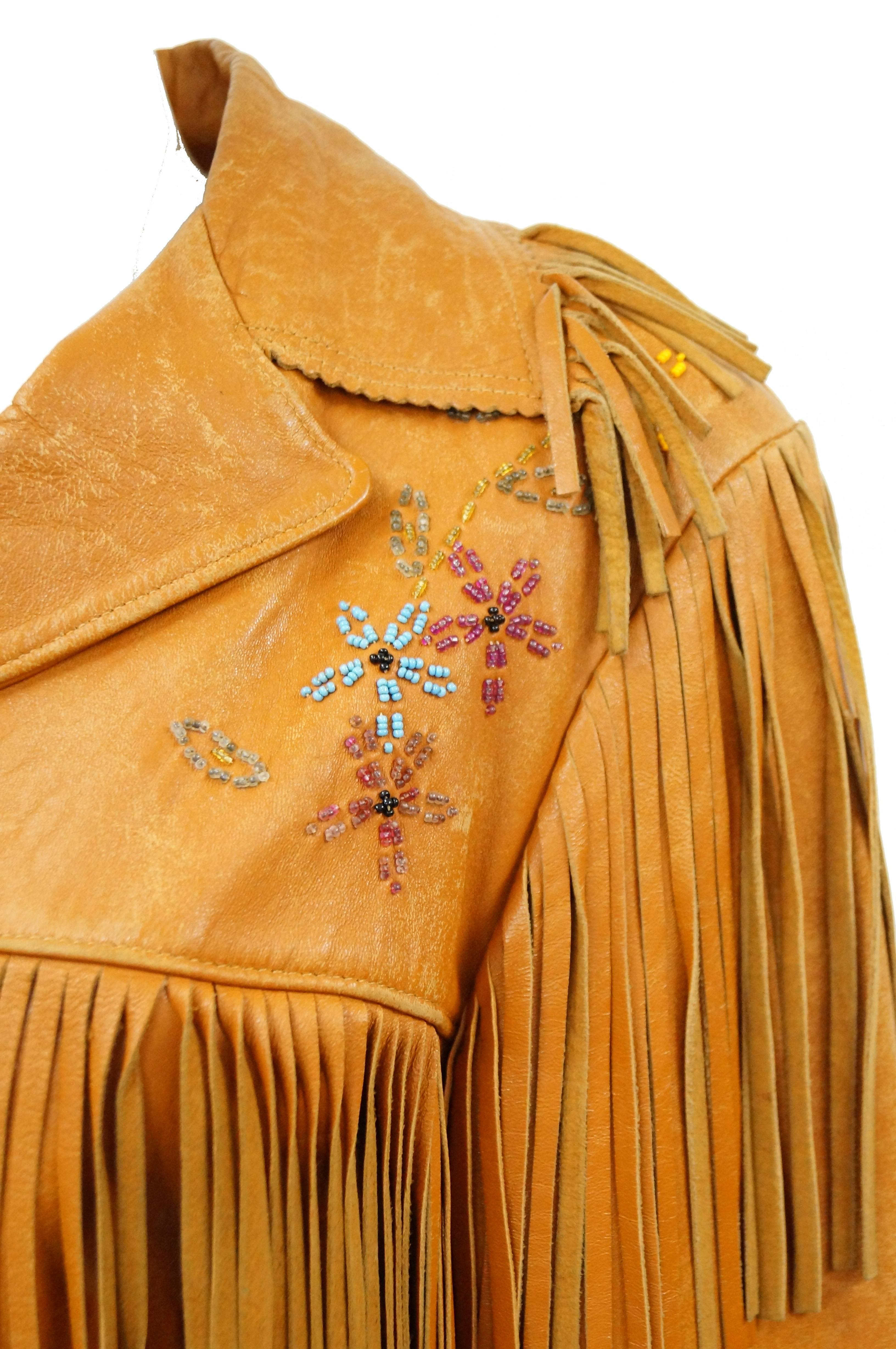 Fabulous authentic 1960s leather jacket! Jacket has pointed collar, long sleeves, hits at the waist. Bust, hem, sleeves, and shoulder feature long fringe. Free spirited boho floral and bird beading on the front and back. Satin lining. Chris Line