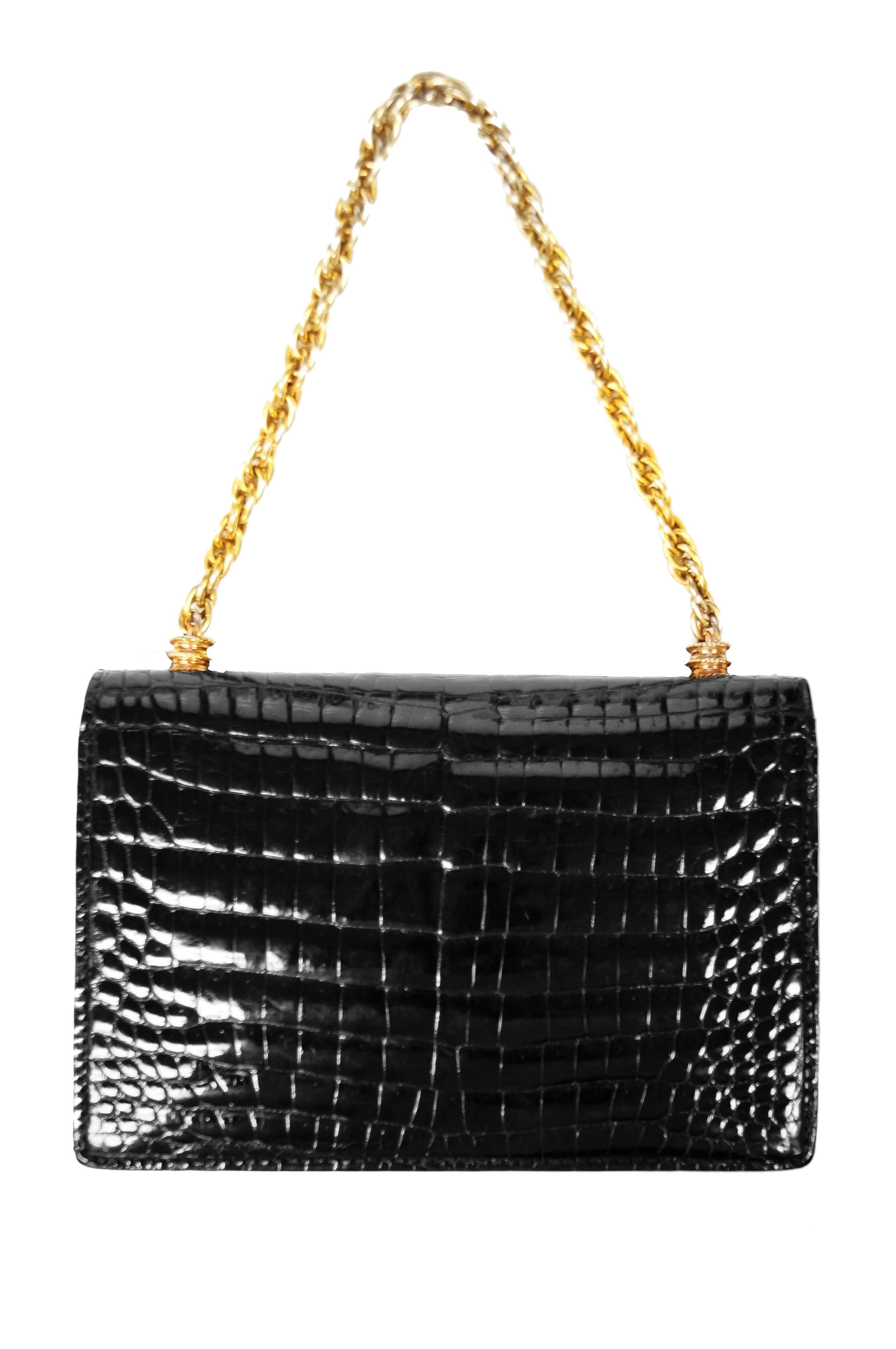 Beautiful glossy black crocodile purse by Gucci. The purse is envelope style, with a heavy brass link chain top handle and turn buckle. Subtle rope detail on handle bases, textured turn lock base. The bag has a bellows construction, with the