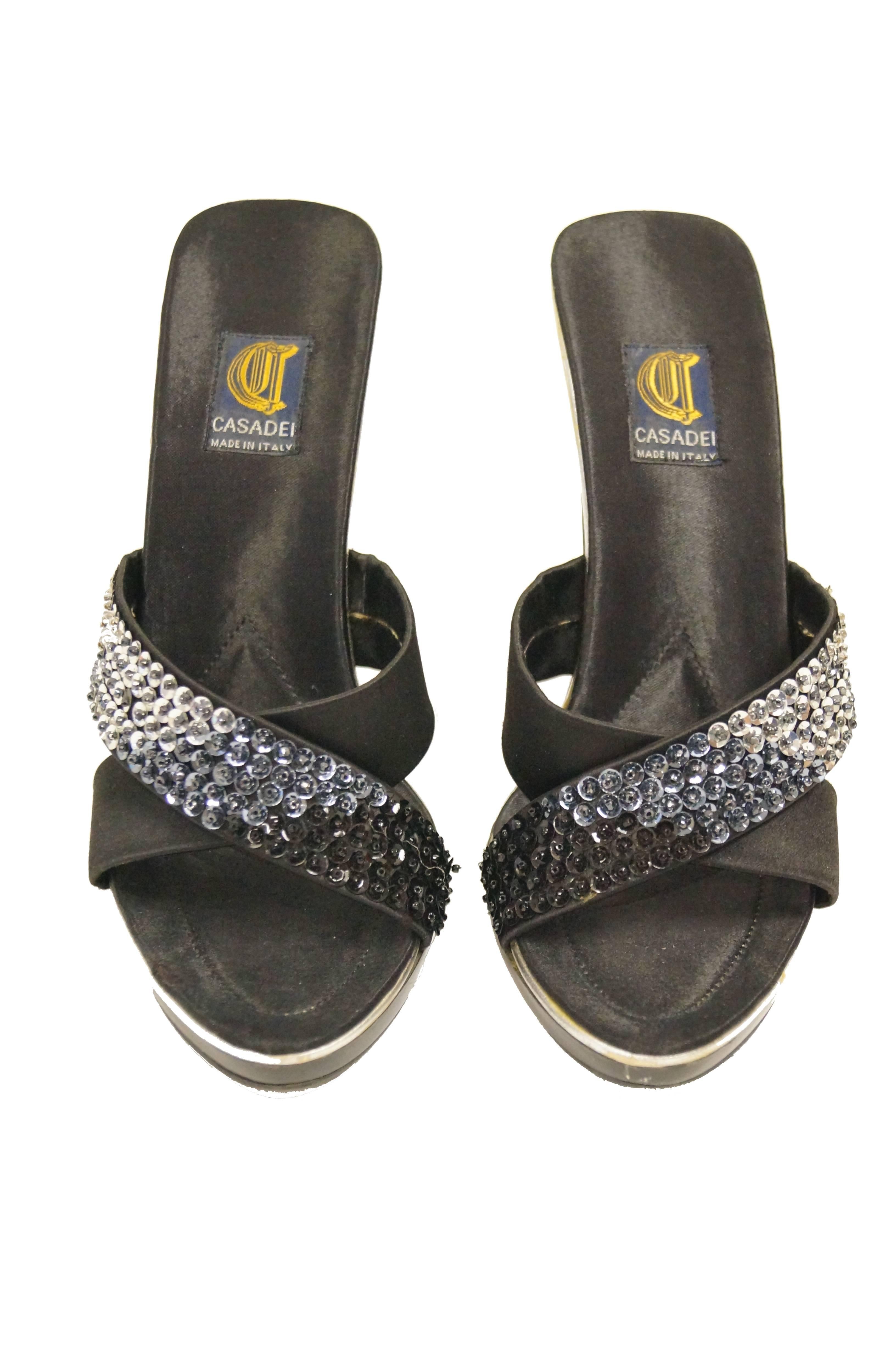 Criss-cross open back sandals by Casadei! The sandals feature two black - to silver ombre sequin satin straps that cross over to form an 
