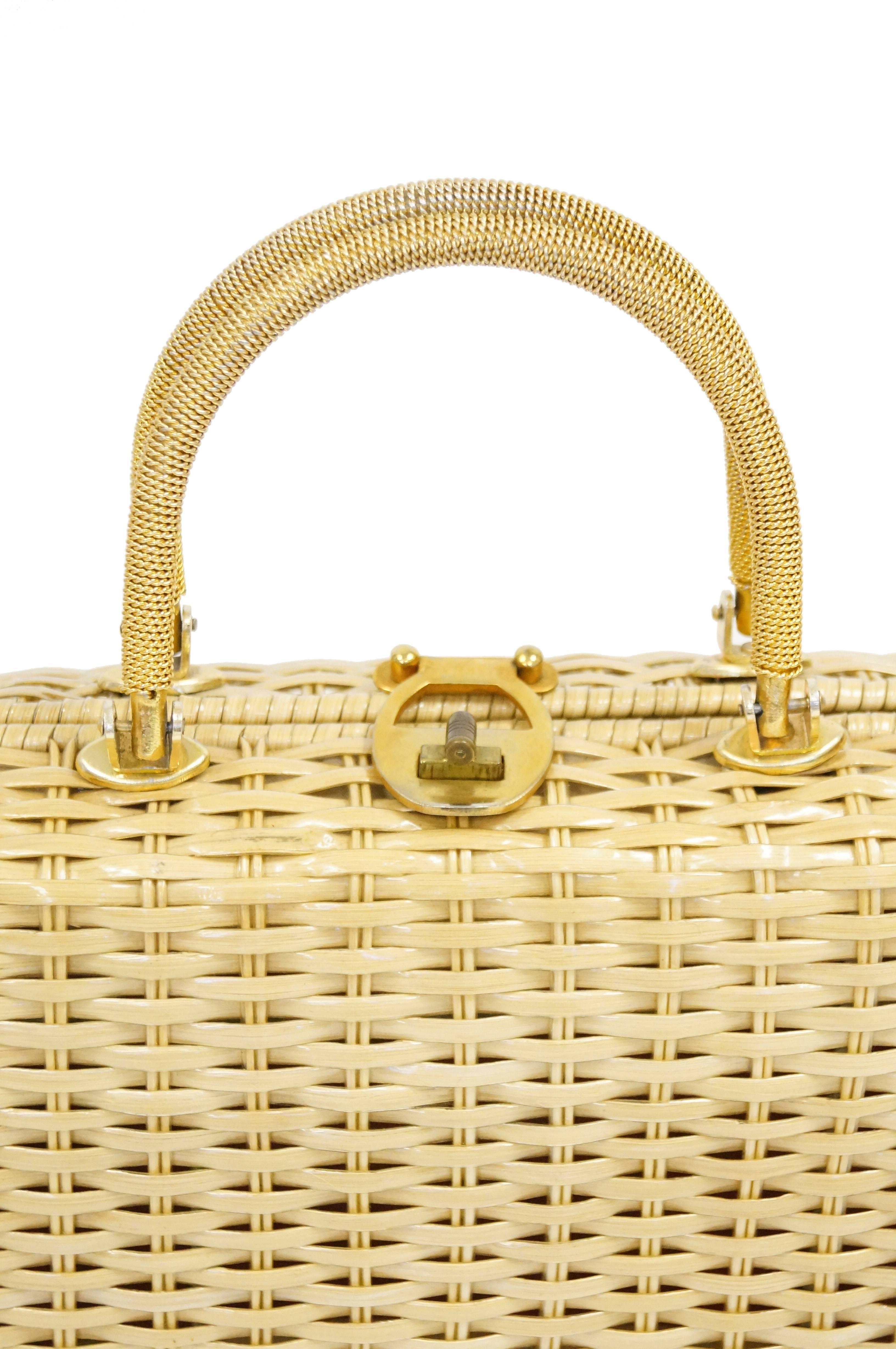 Playful yet elegant natural flaxen - tone wicker handbag by Lesco Lona. The bag is a structured briefcase composed of clear plastic coated wicker, spiraled gold handles, and a gold twist lock. The interior is plastic lined and features a wide