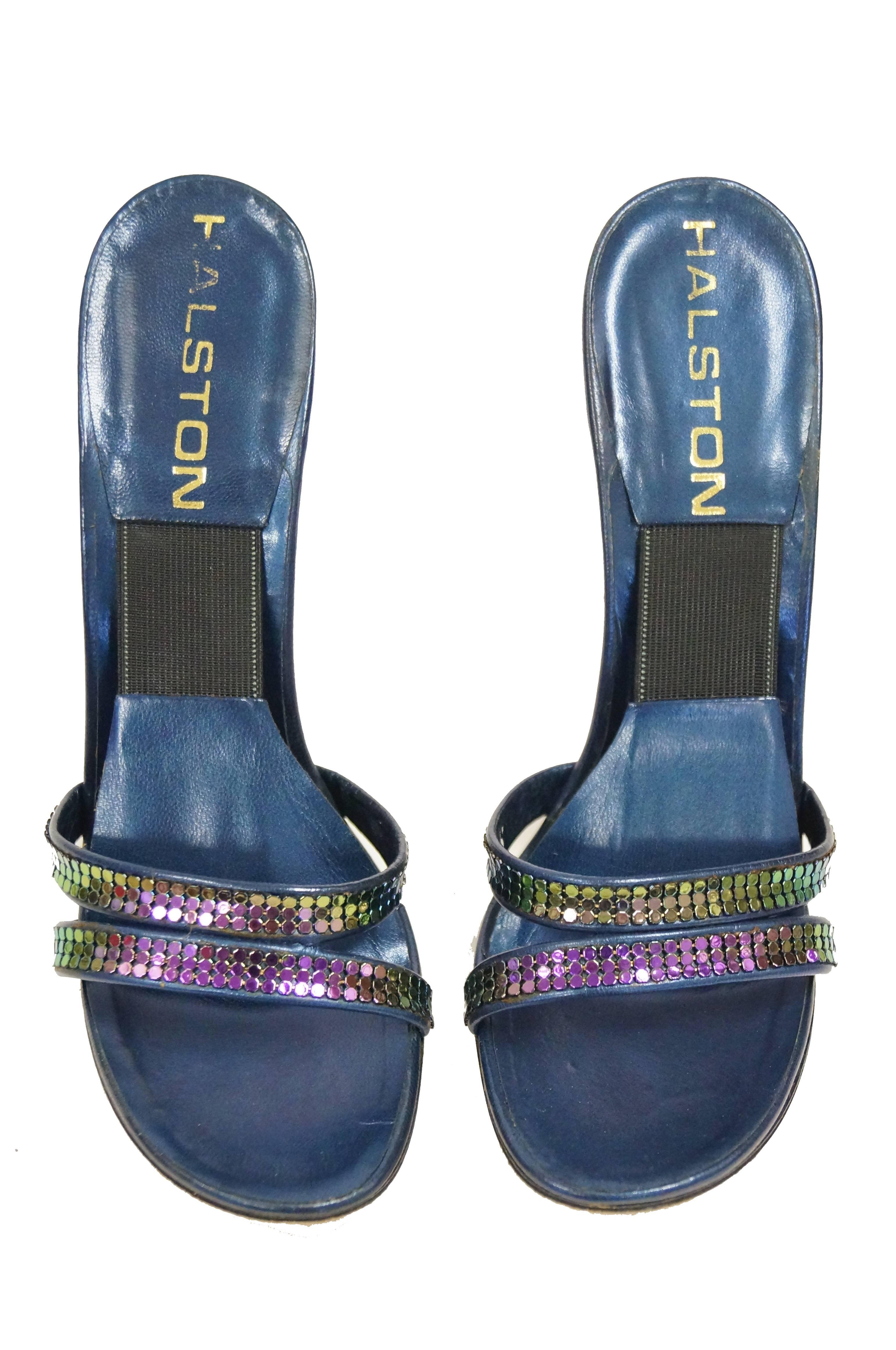 Disco diva mule heels by Halston! Glossy navy blue shoes feature a high heel, low platform, and thin shank with sleek silhouette. The double - strap upper features amazing oil - slick iridescent chainmail details reminiscent of the popular Whiting